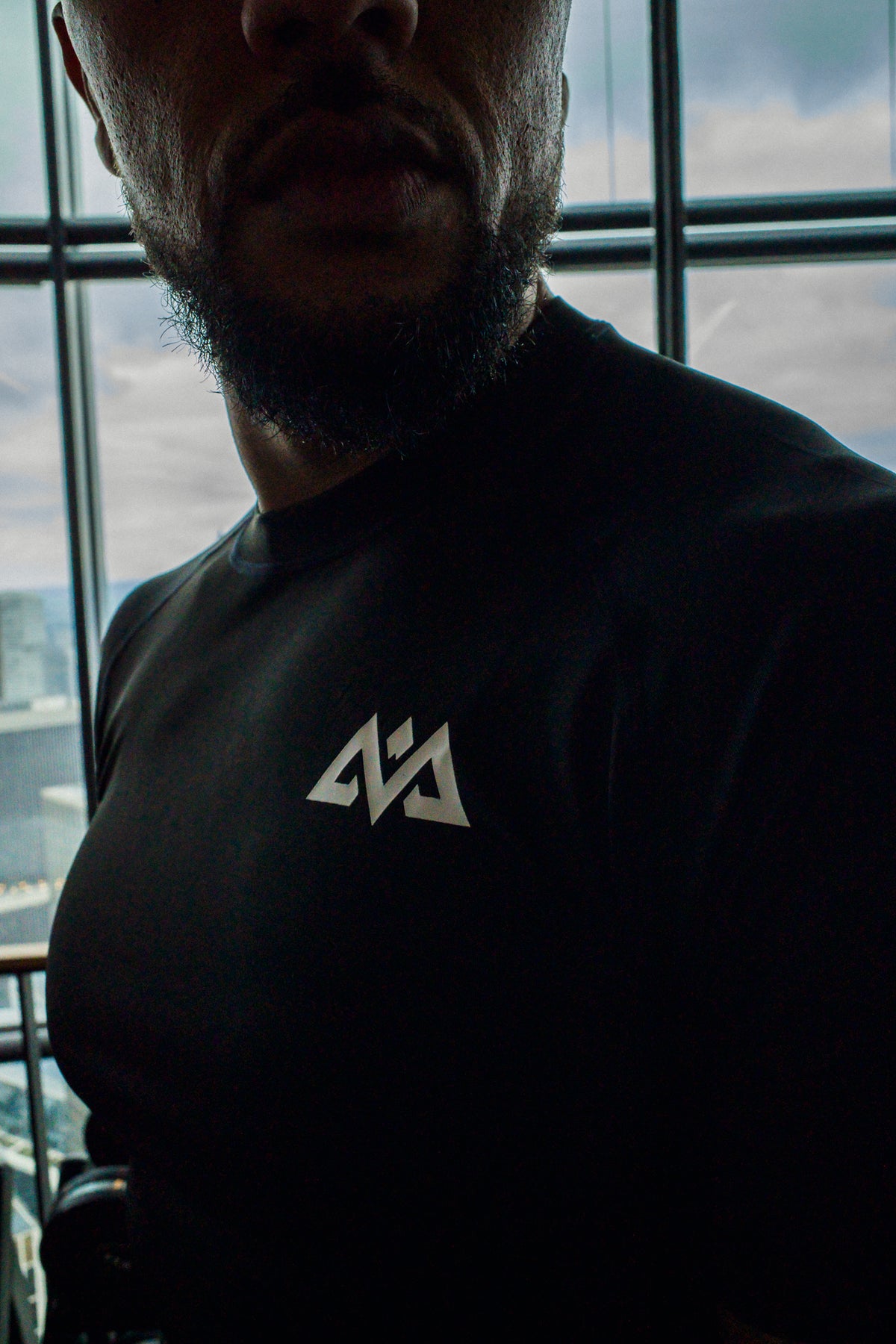 Nahaufnahme des weißen Brustlogos am schwarzen T-Shirt