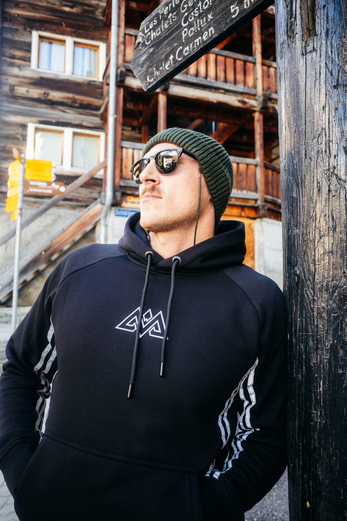 Black hoodie with large white logo and reflective stripes on sleeves