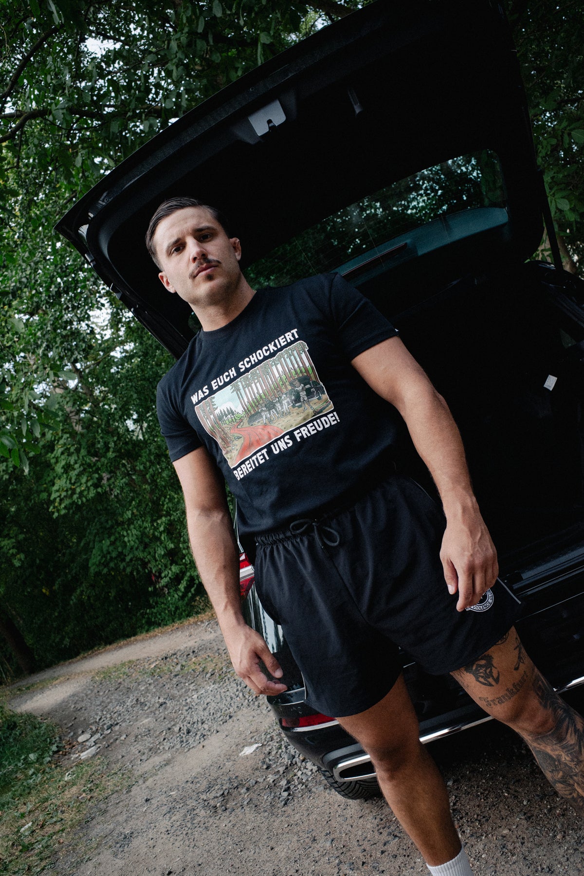 Black crewneck T-shirt with rectangular forest scene and white typography