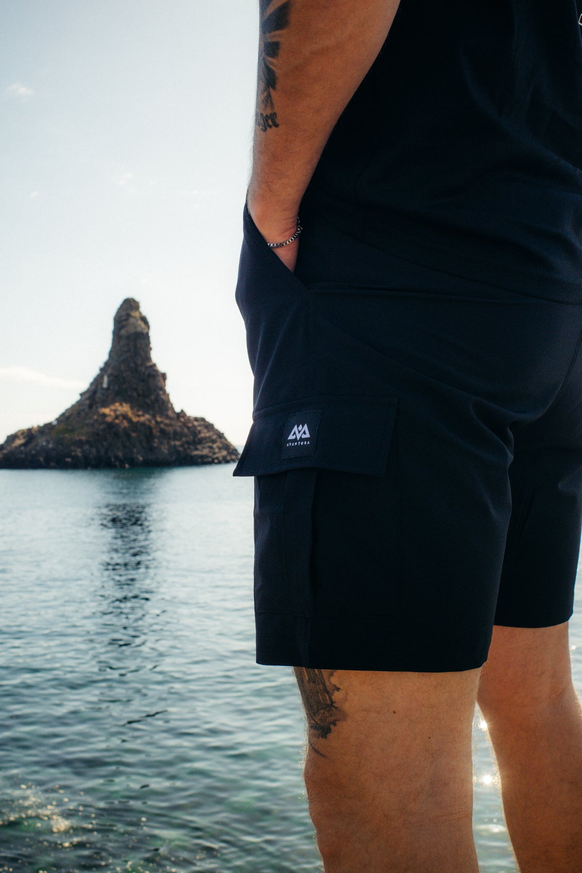 Seitenansicht schwarze Cargoshorts mit Hand in Seitentasche und Logo