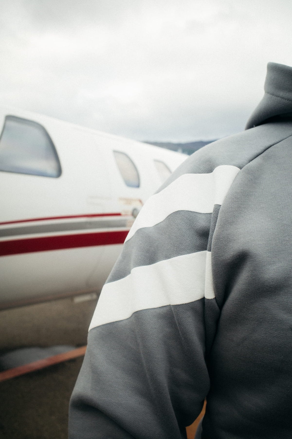 Close-up of white stripes on the grey hoodie sleeve