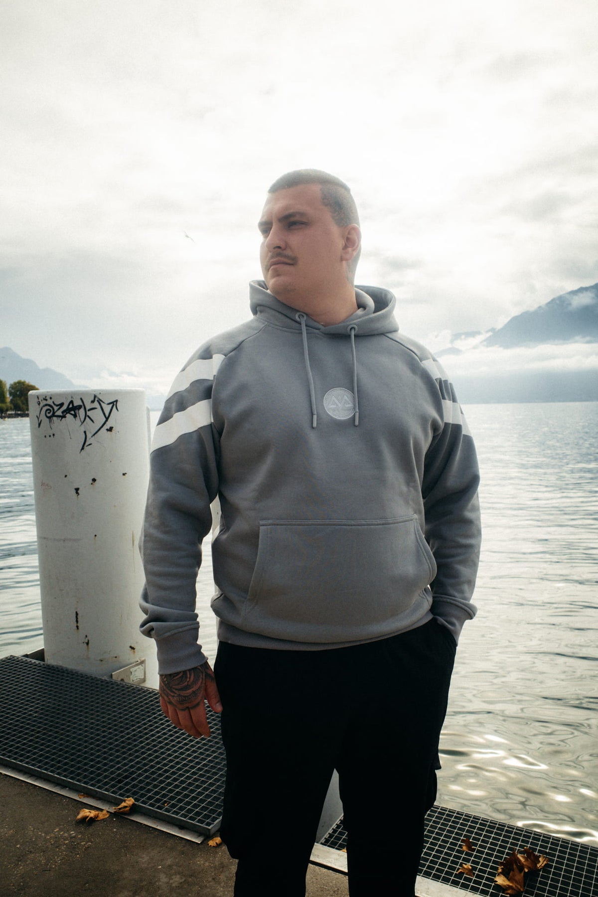 Grey striped hoodie worn outdoors with mountains in the background