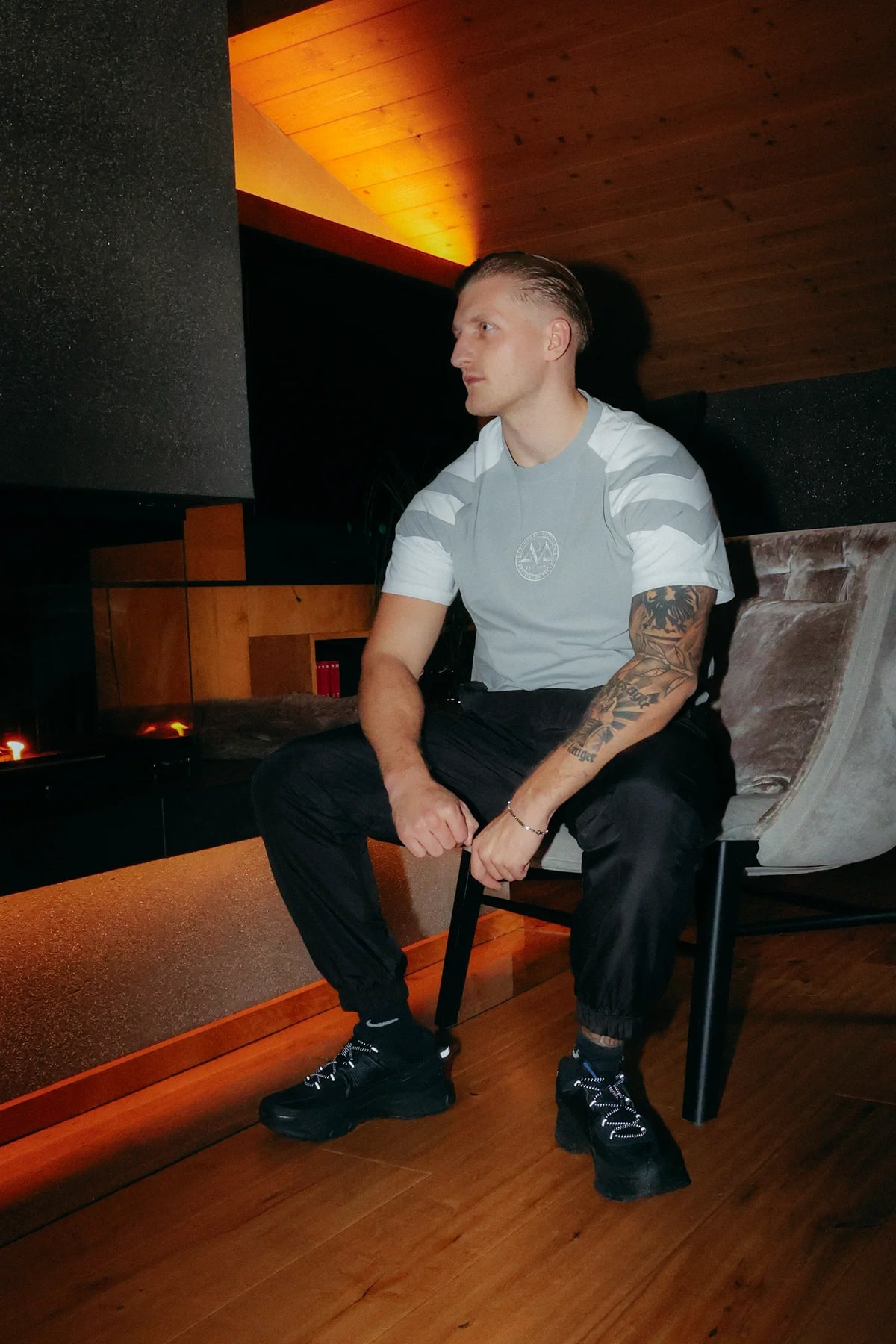 Gray striped t-shirt worn while sitting in profile