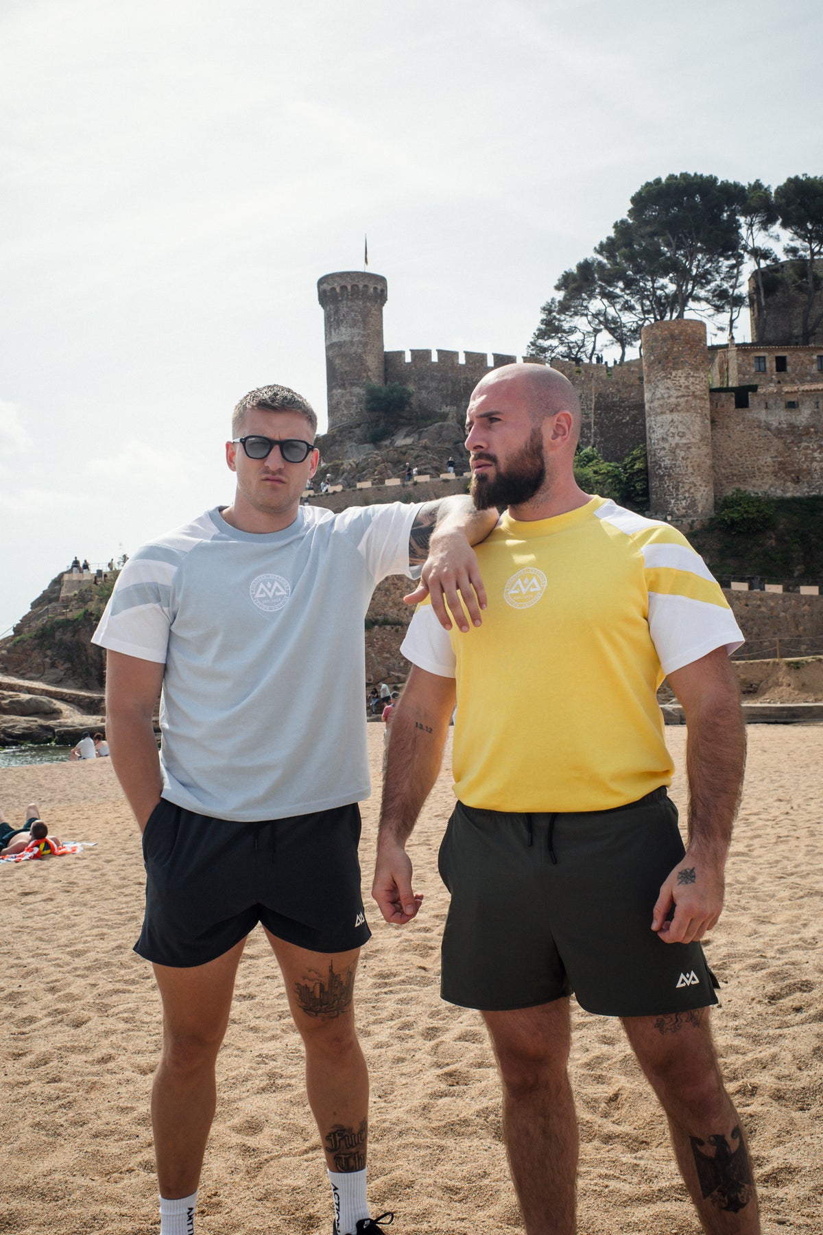 Couple wearing light blue and yellow striped t-shirts at coastal location