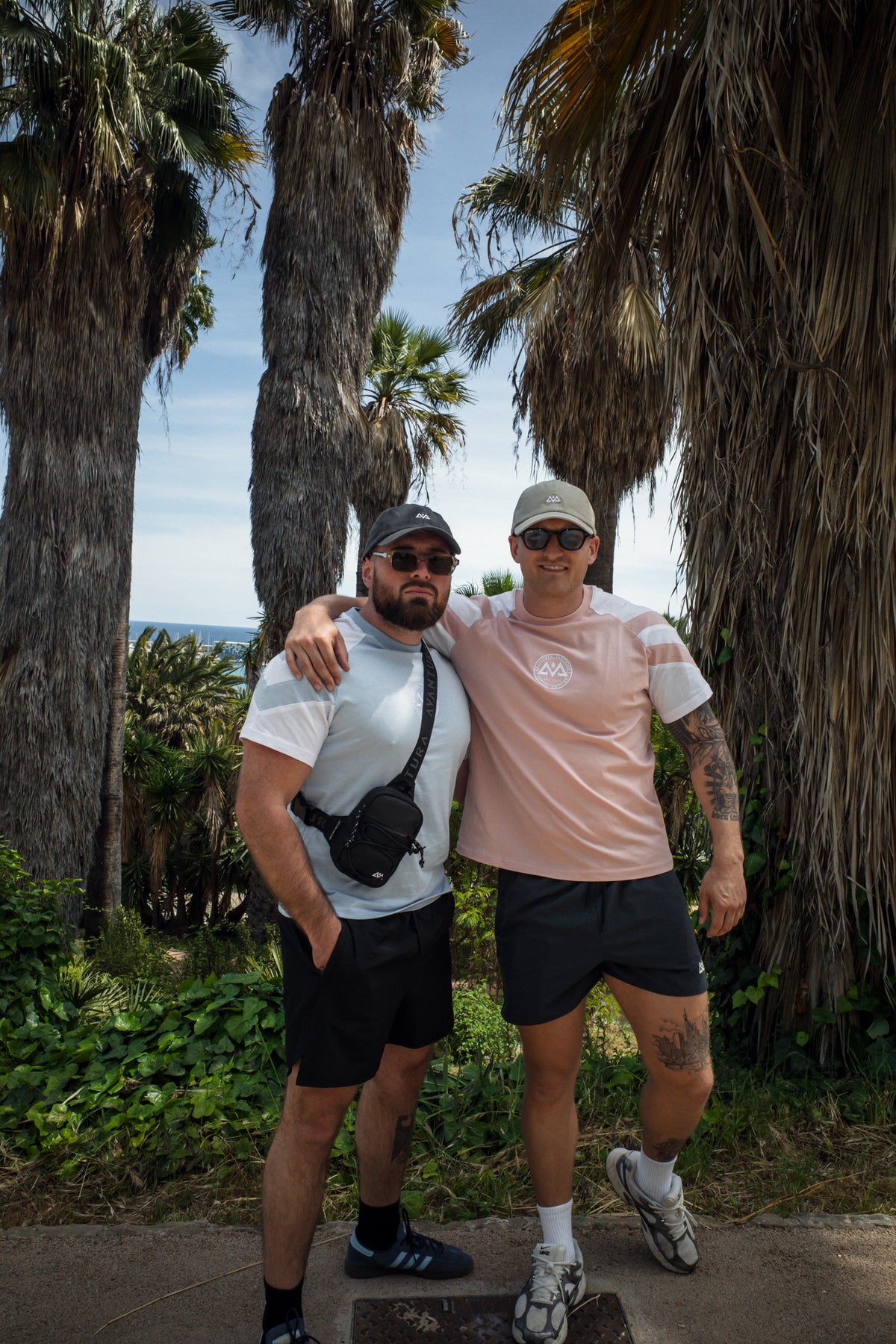 Rosa-weißes Streifen-T-Shirt mit Logo-Stick am Strand getragen