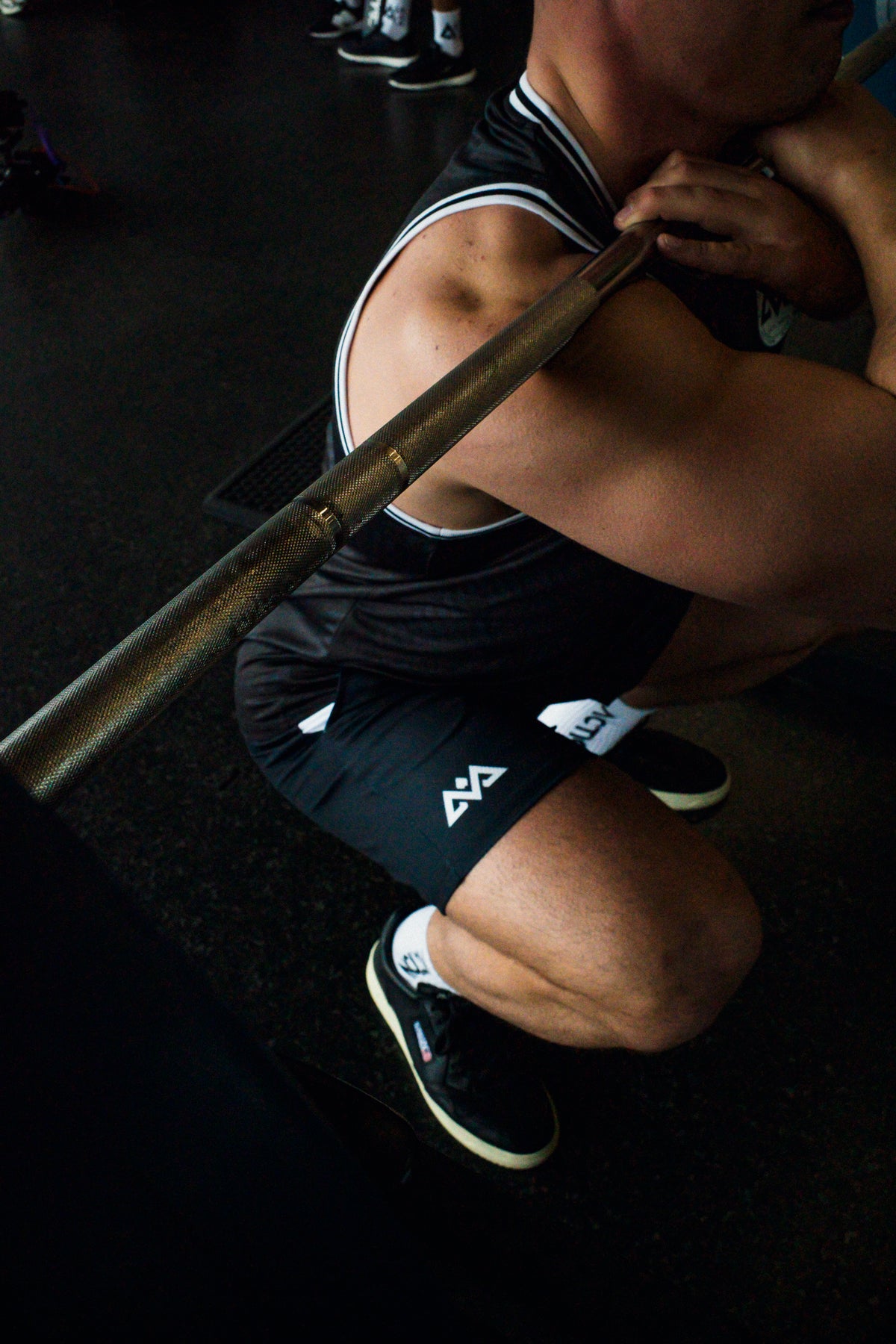 Man squatting in black mesh shorts with white side stripe
