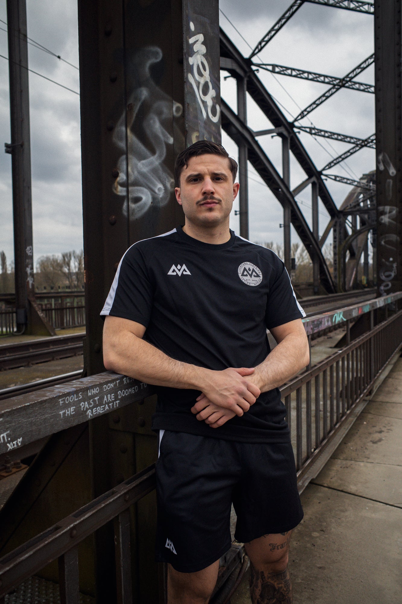 Black technical mesh t-shirt with white sleeve stripes and chest logos