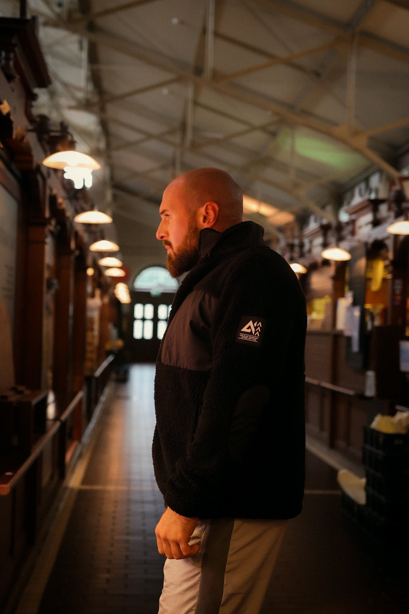 Black fleece jacket featuring white mountain logo patch on left sleeve