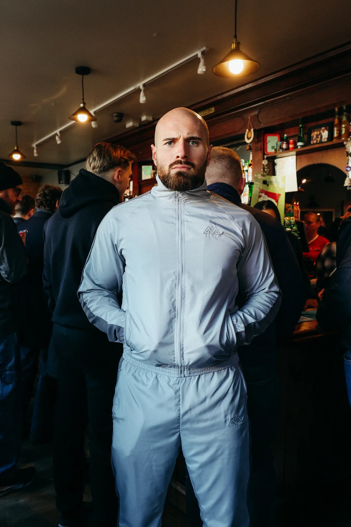 Man wearing grey Avantura trackjacket with zip pockets in pub