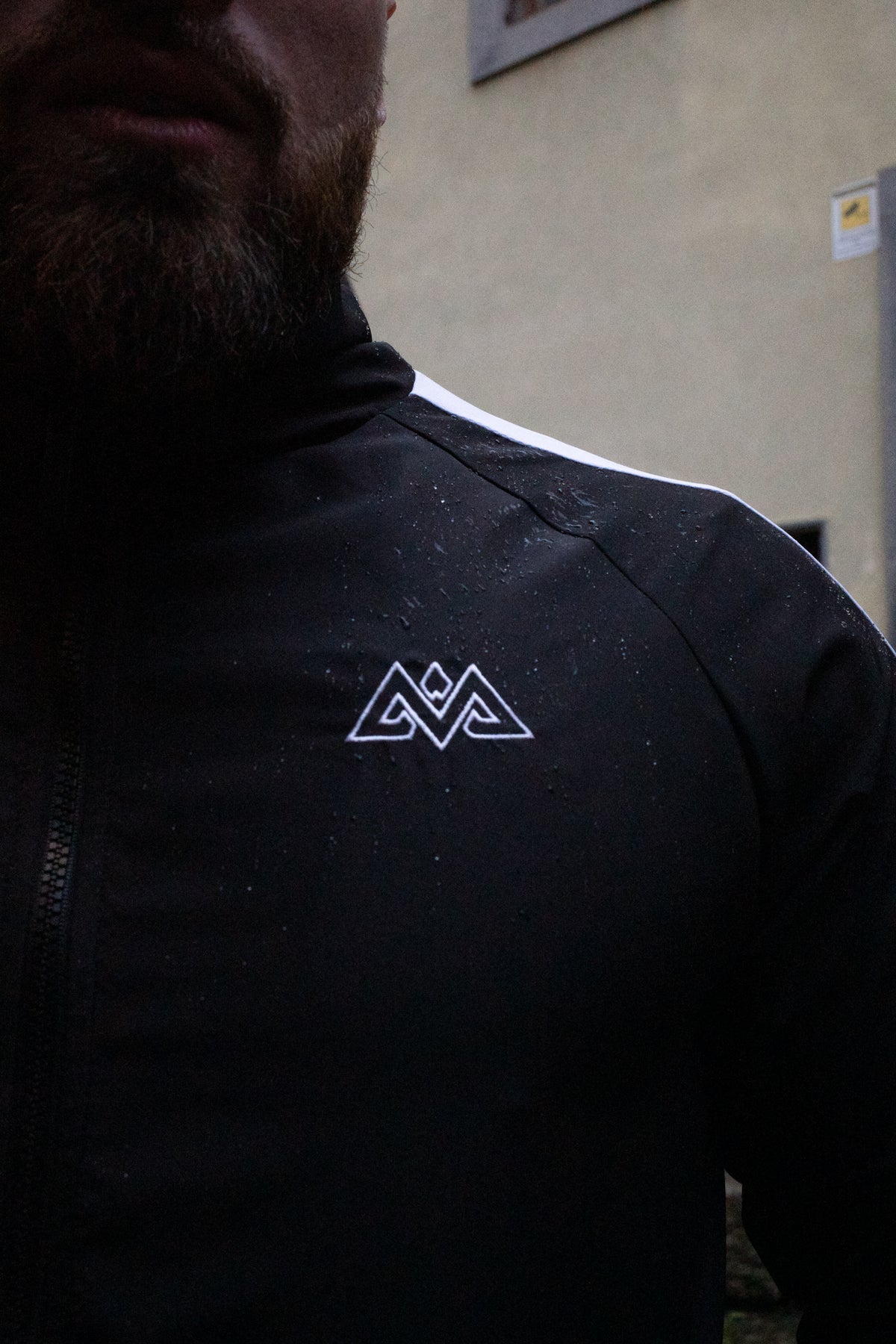 Detail: Gesticktes Logo und wasserabweisender Stoff der Trackjacke