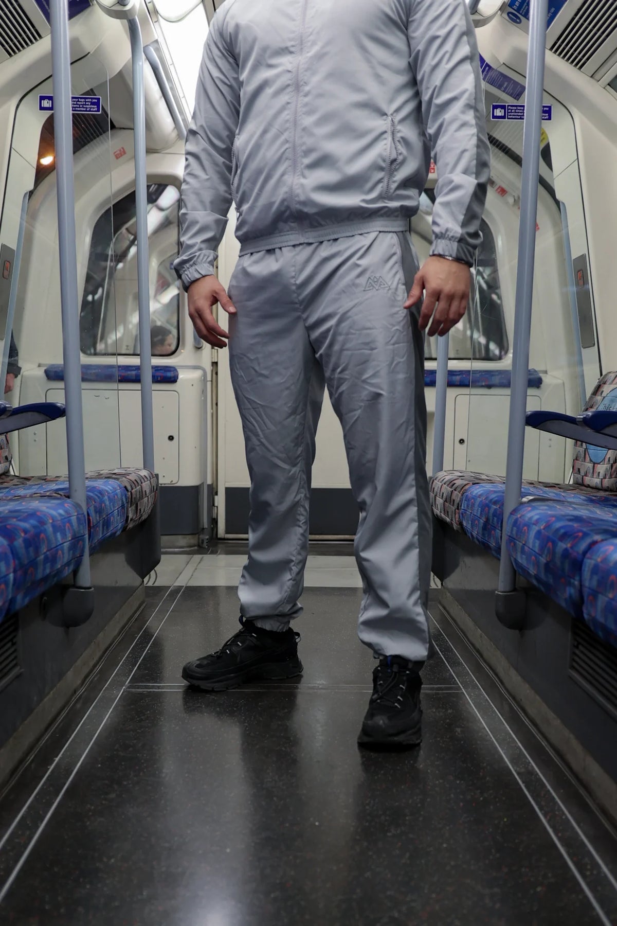 Graue Trackpants im urbanen U-Bahn-Umfeld getragen