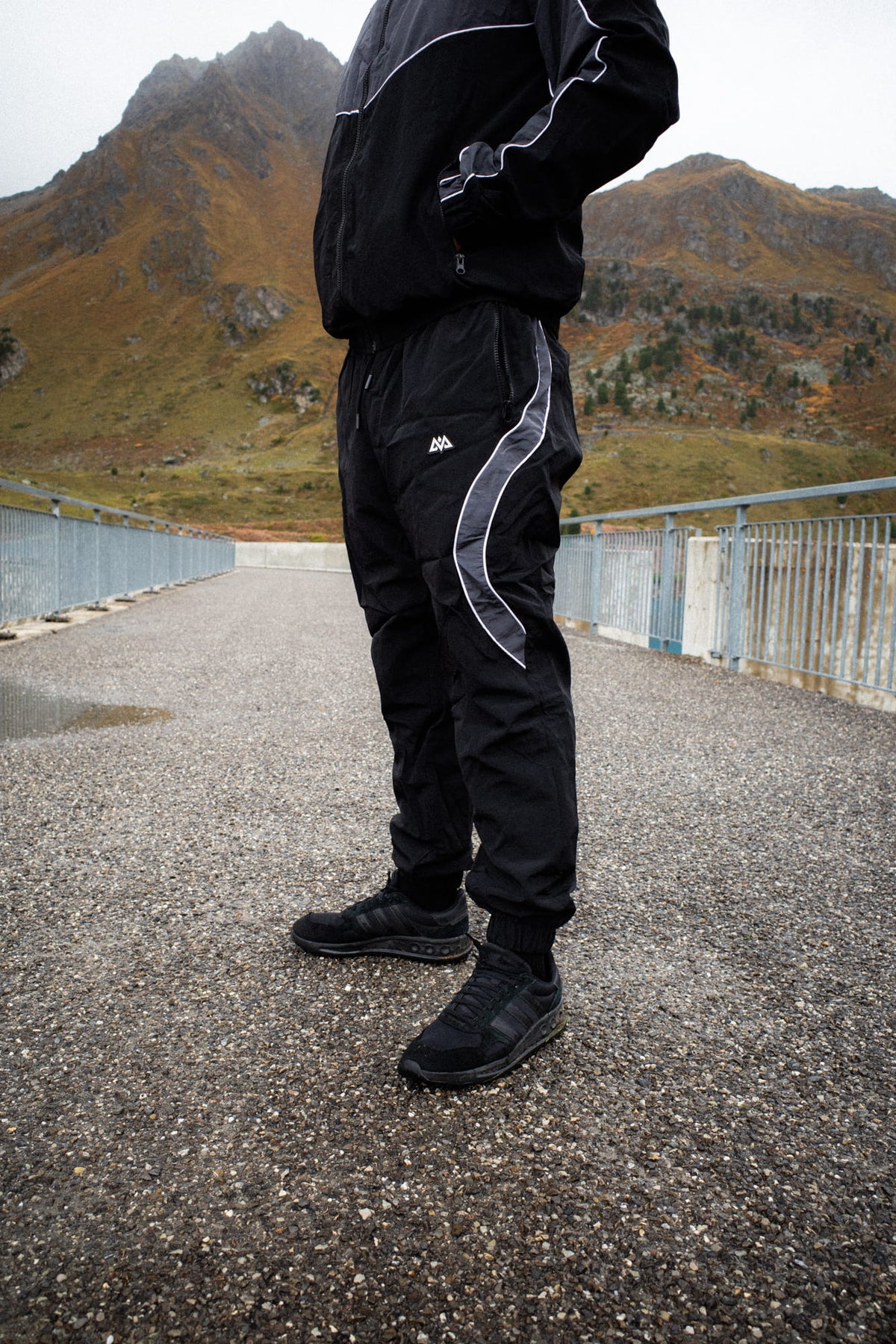 Schwarze Trackpants im Outdoor-Einsatz mit Berglandschaft