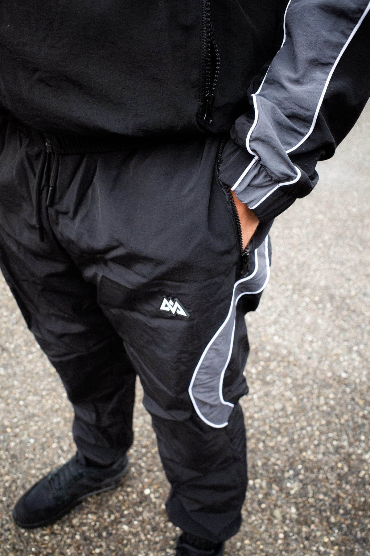 Schwarze Trackpants mit grauer Seitenpartie und Reißverschlusstasche