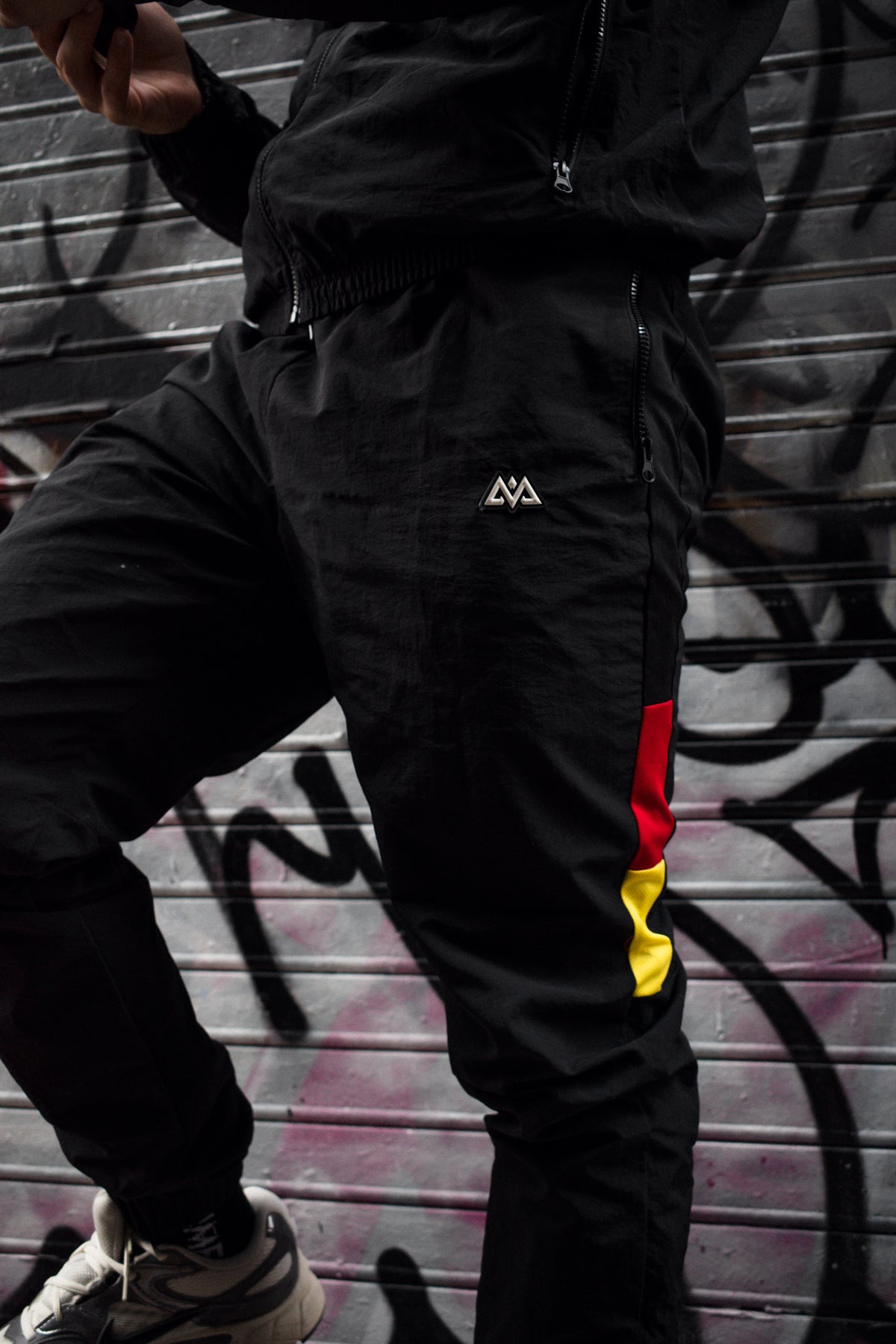 Full view of black trackpants with drawstring waist
