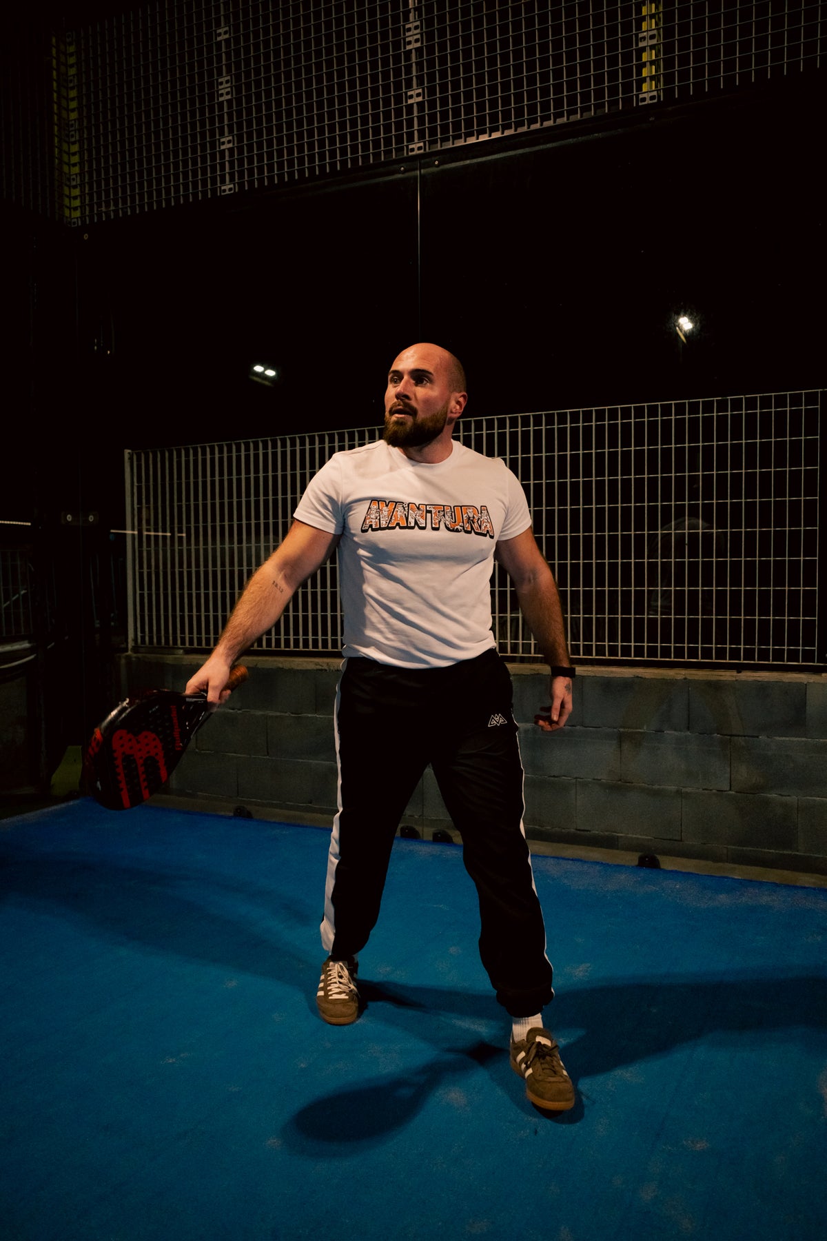 Schwarze Trackpants mit weißem Streifen und Logo, kombiniert mit weißem T-Shirt