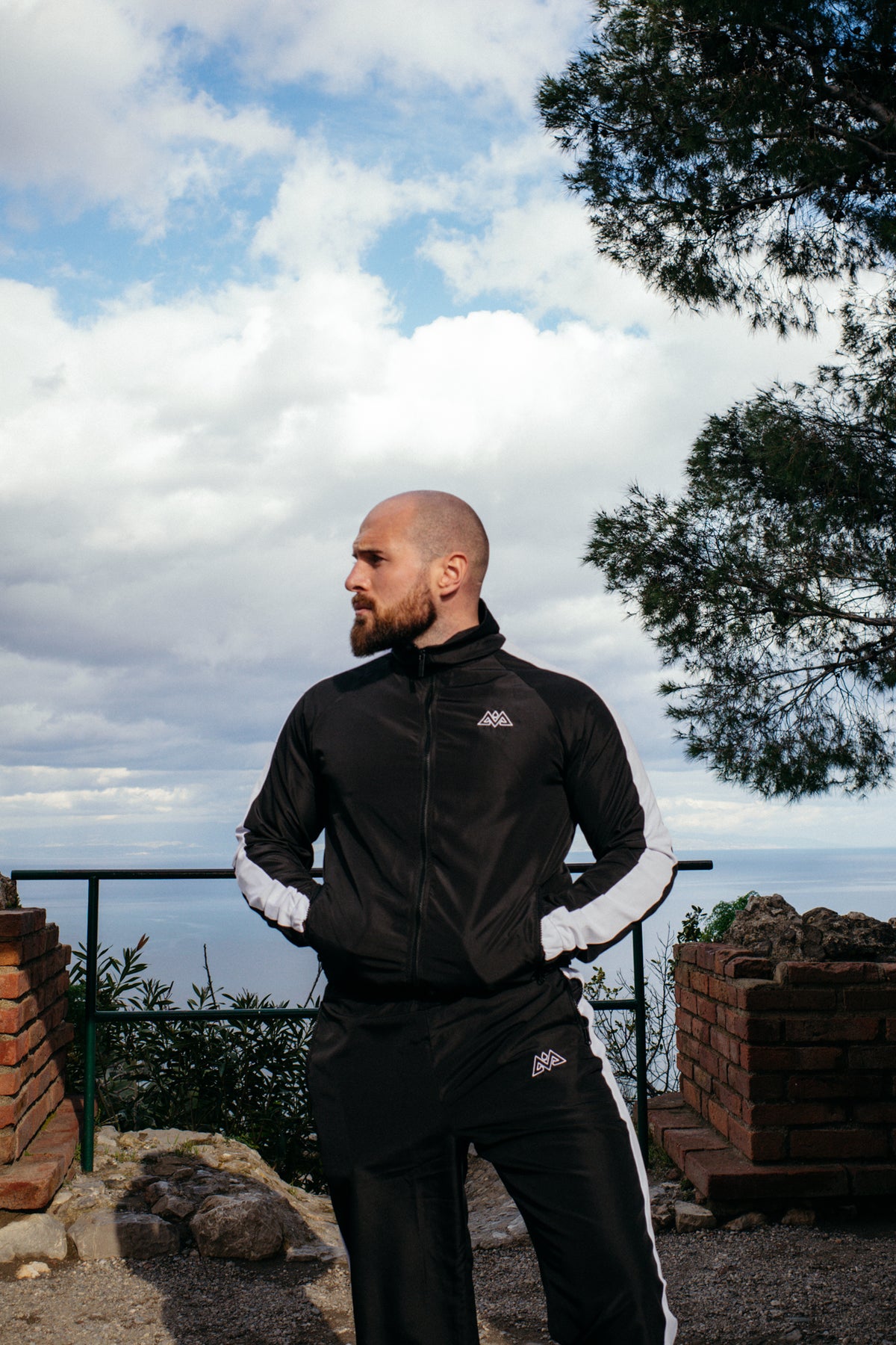 Profilansicht schwarzer Tracksuit mit Logos am Meer