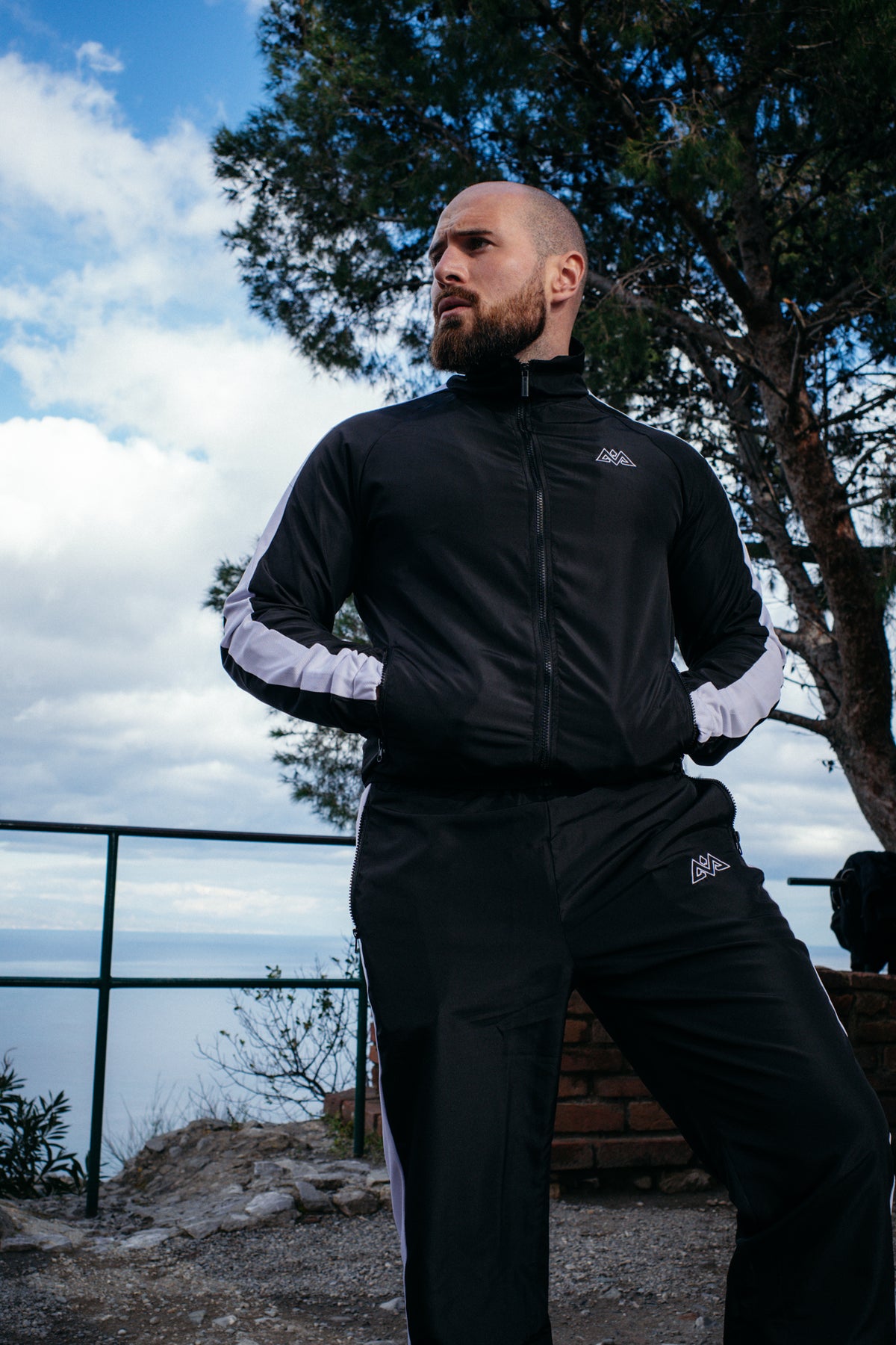 Black tracksuit with white side stripes outdoors