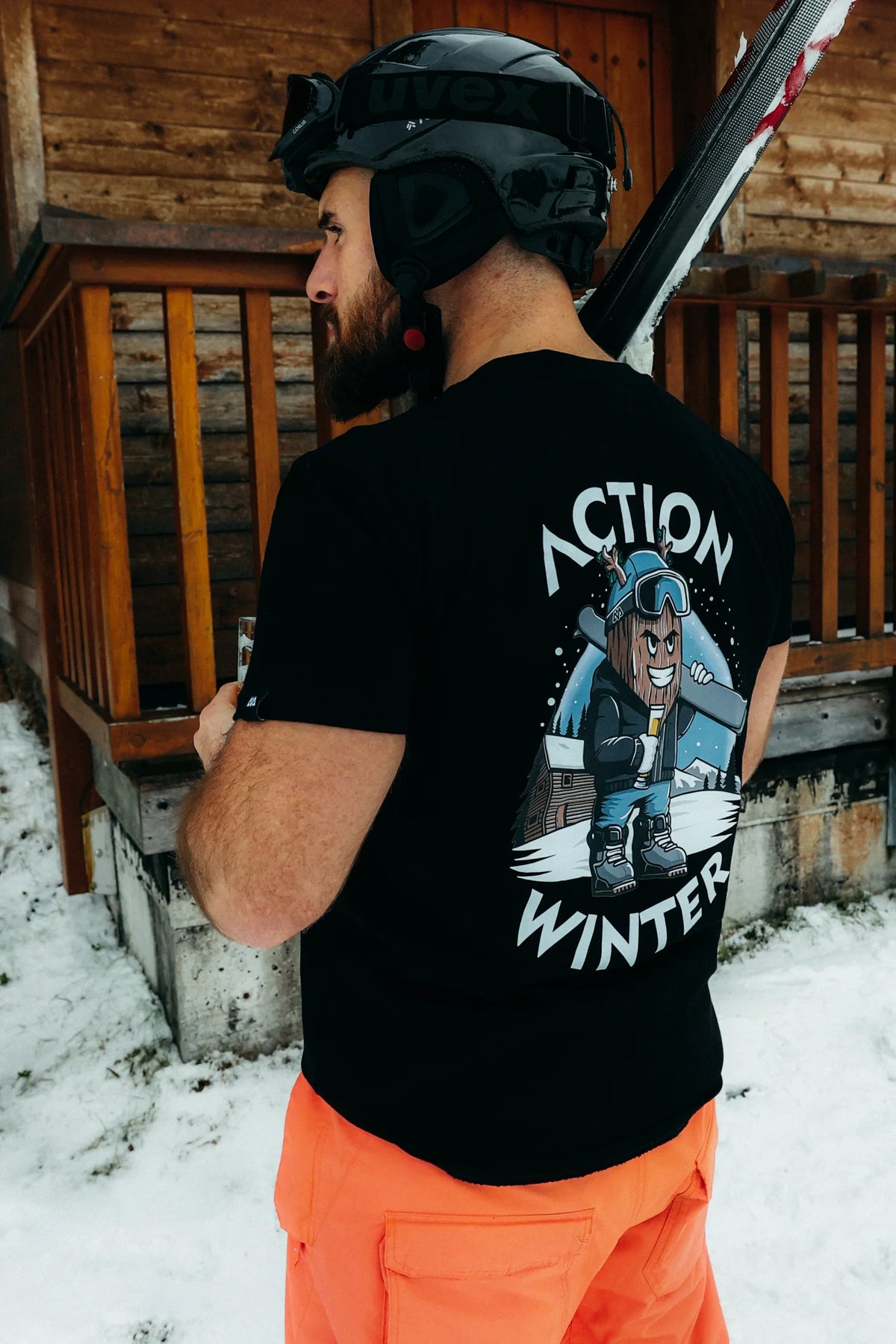 Close-up of back print on black T-shirt showing cartoon skier and 'Action Winter' text