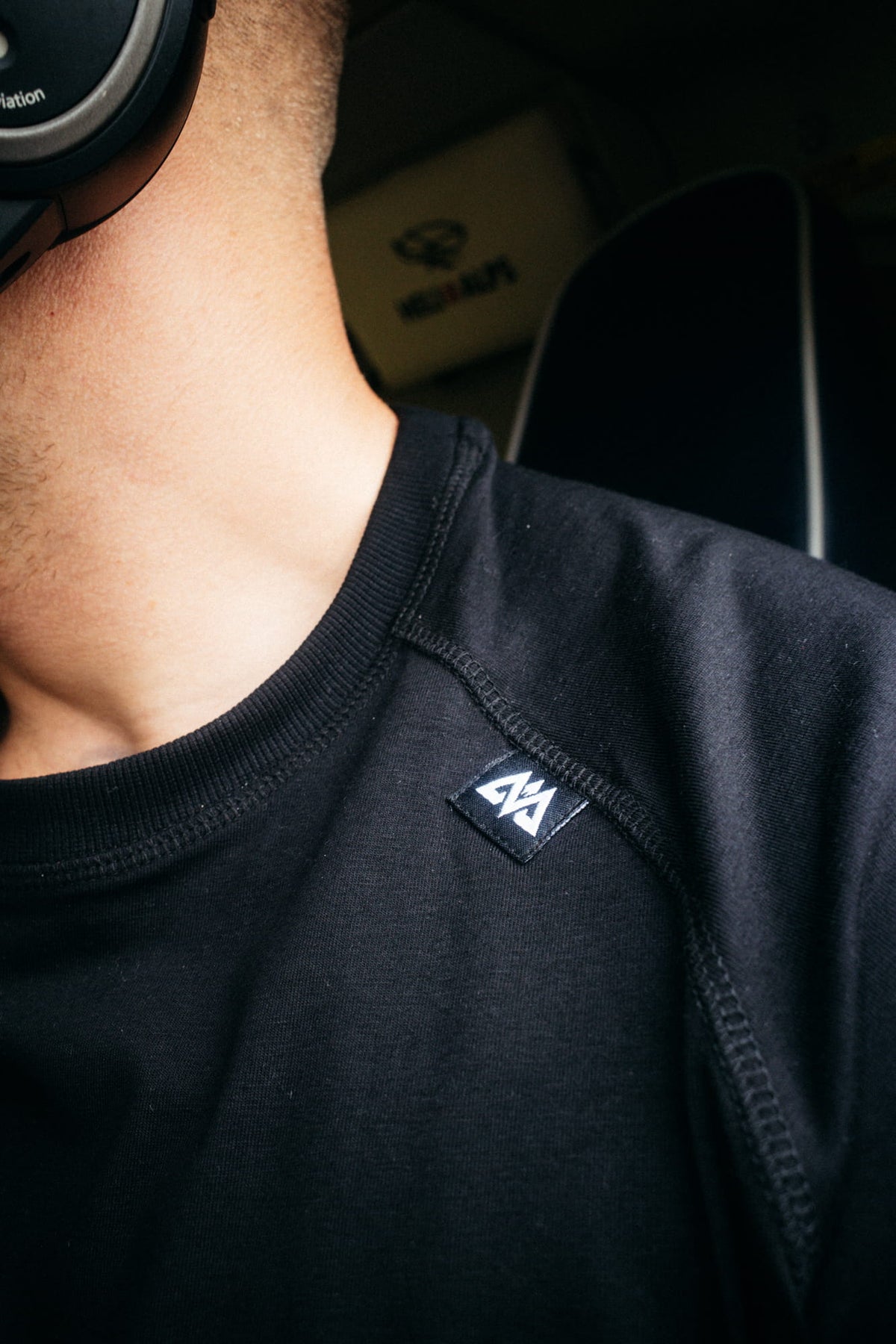 Detailansicht gewebtes Label und Raglan-Nähte am schwarzen T-Shirt