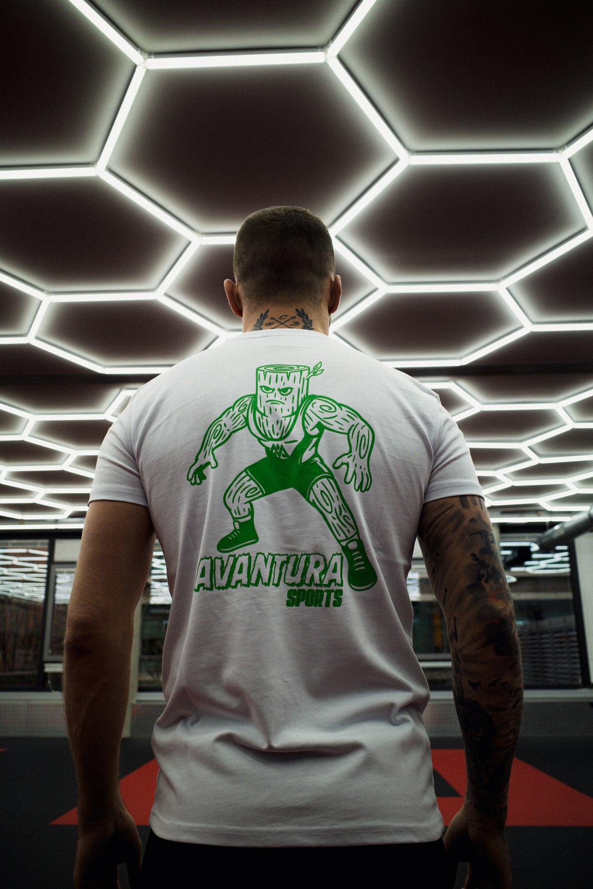 Back view of white T-shirt with woodblock wrestling print and woven labels