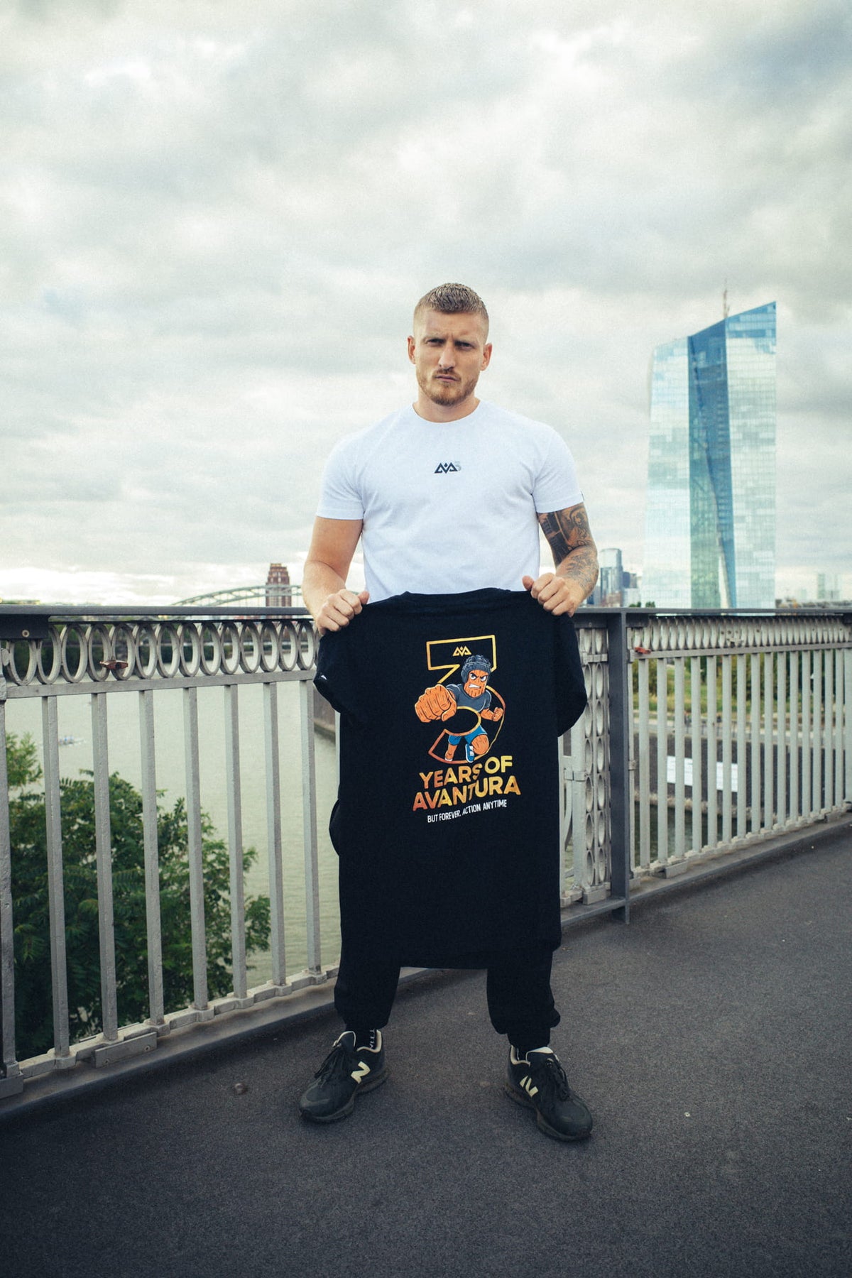 Schwarzes T-Shirt mit großem Rückenmotiv in der Hand gehalten