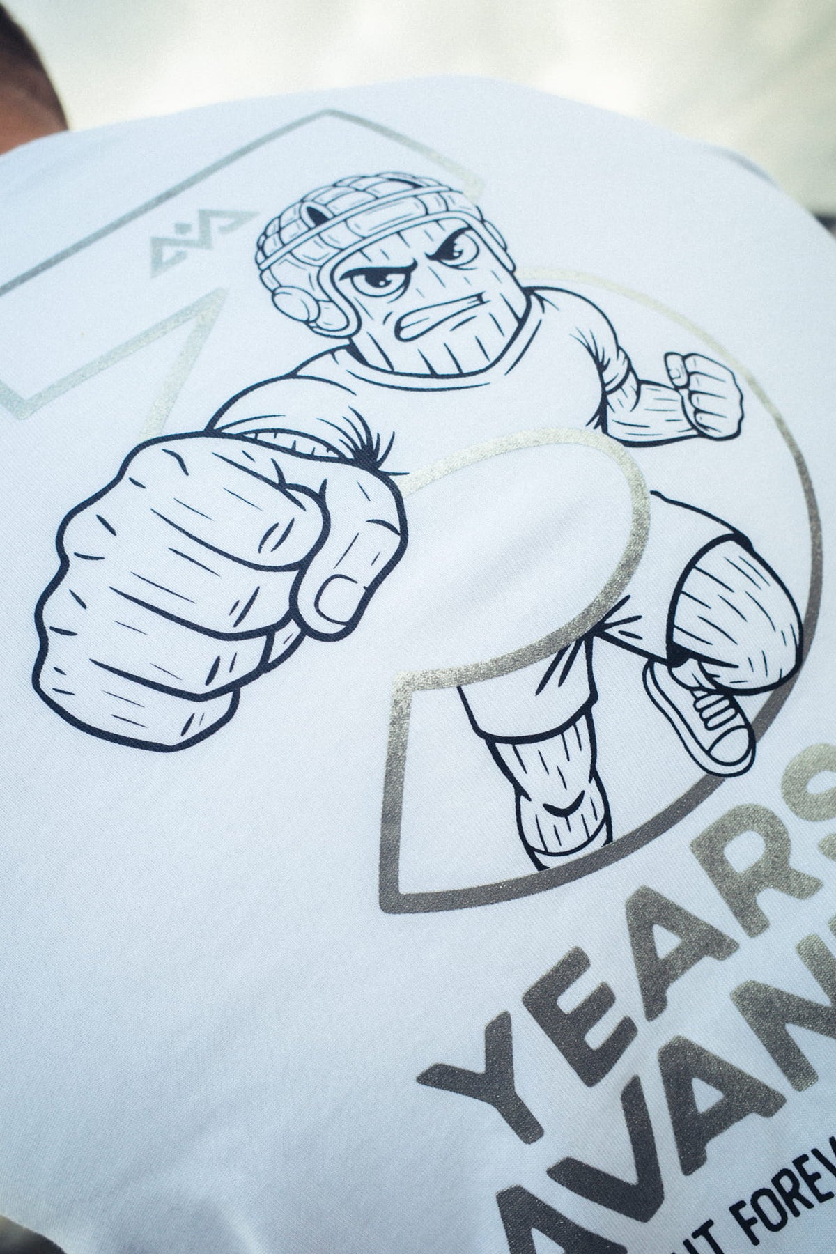 Detail Großprint weißes T-Shirt: Boxer-Figur aus silberner 3 mit YEARS AVANTURA Text