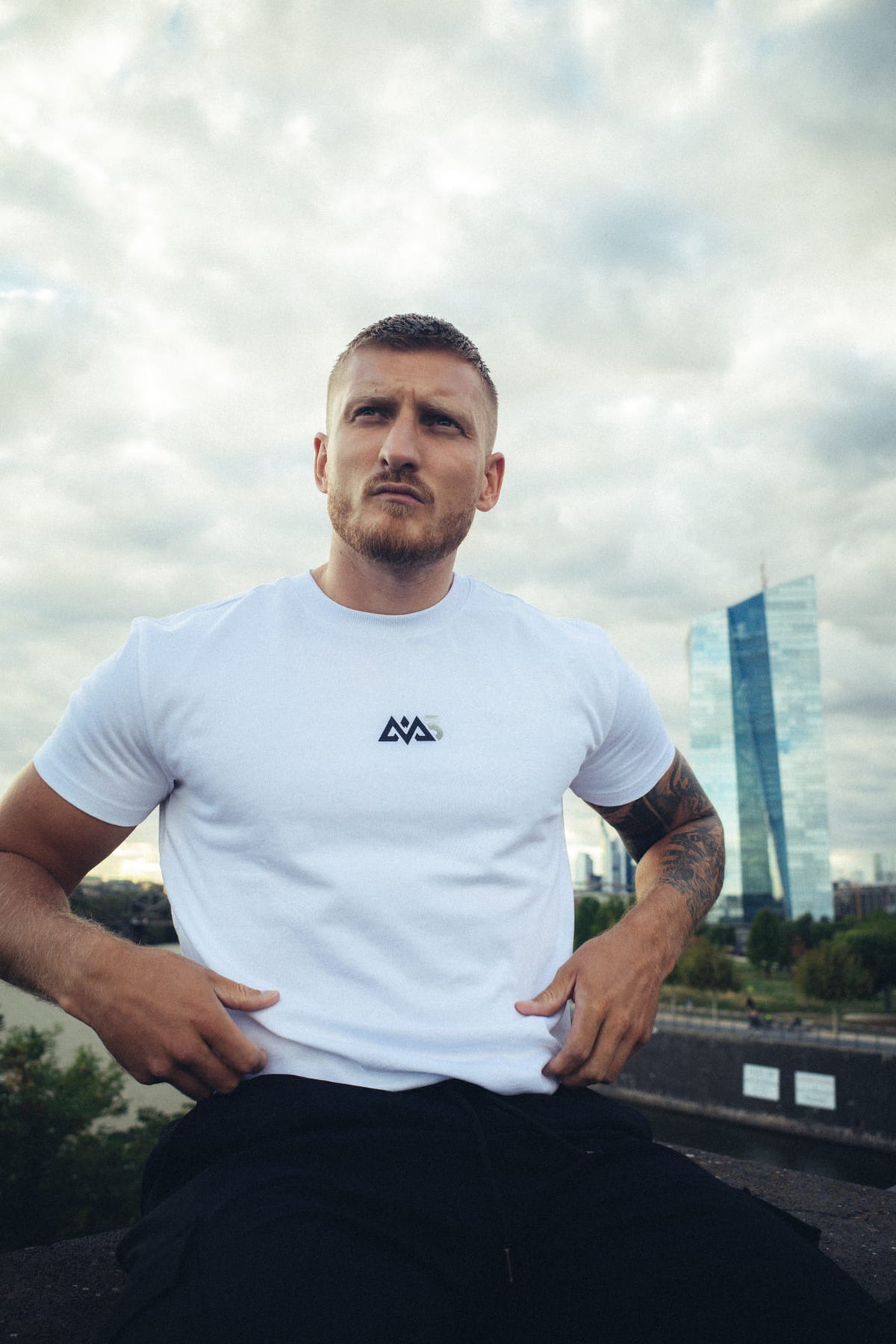 Weißes Kurzarm-T-Shirt mit dunkelblauem geometrischem Logo auf der Brust