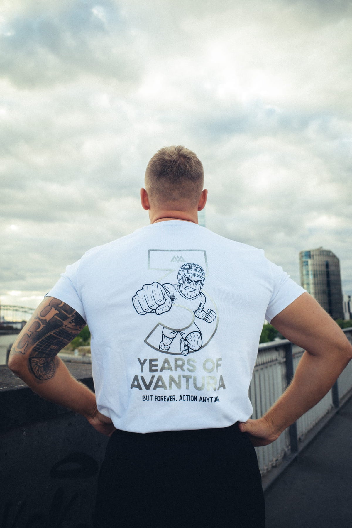 Rückansicht weißes T-Shirt mit Cartoon-Figur in Zahl 3 und ACTION ANYTIME Text
