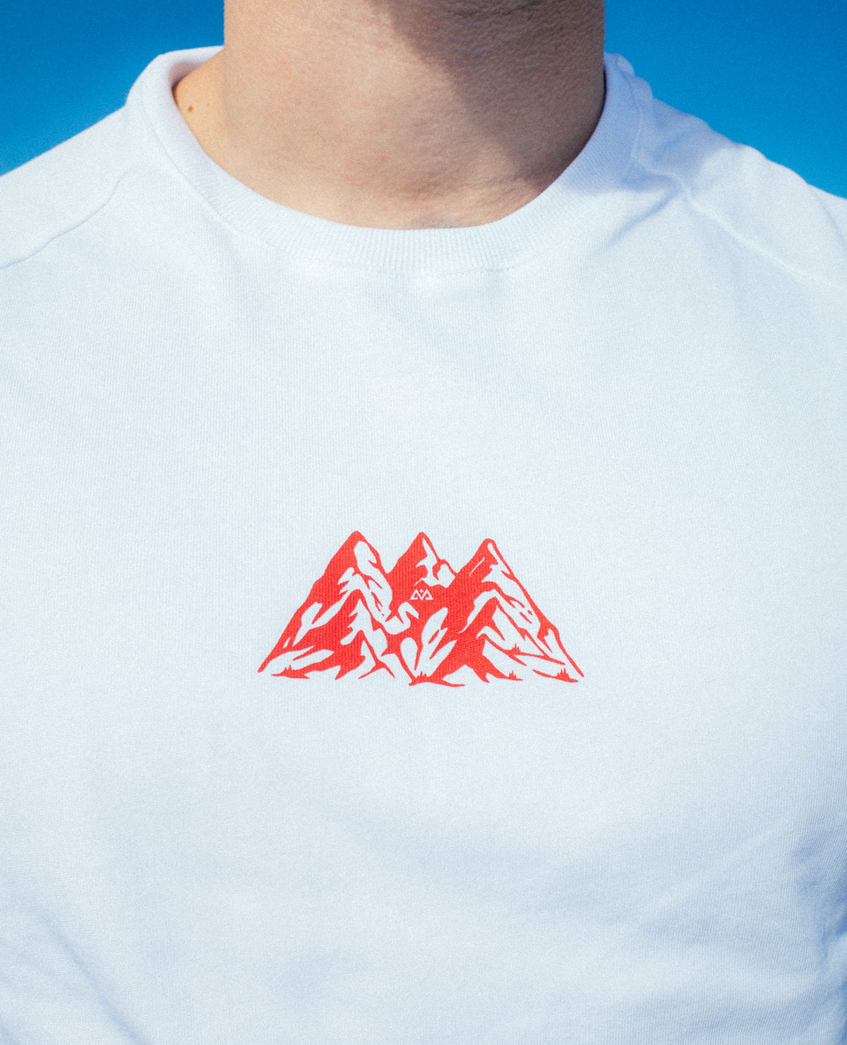 Detail shot red print logo with three mountain peaks on white T-shirt