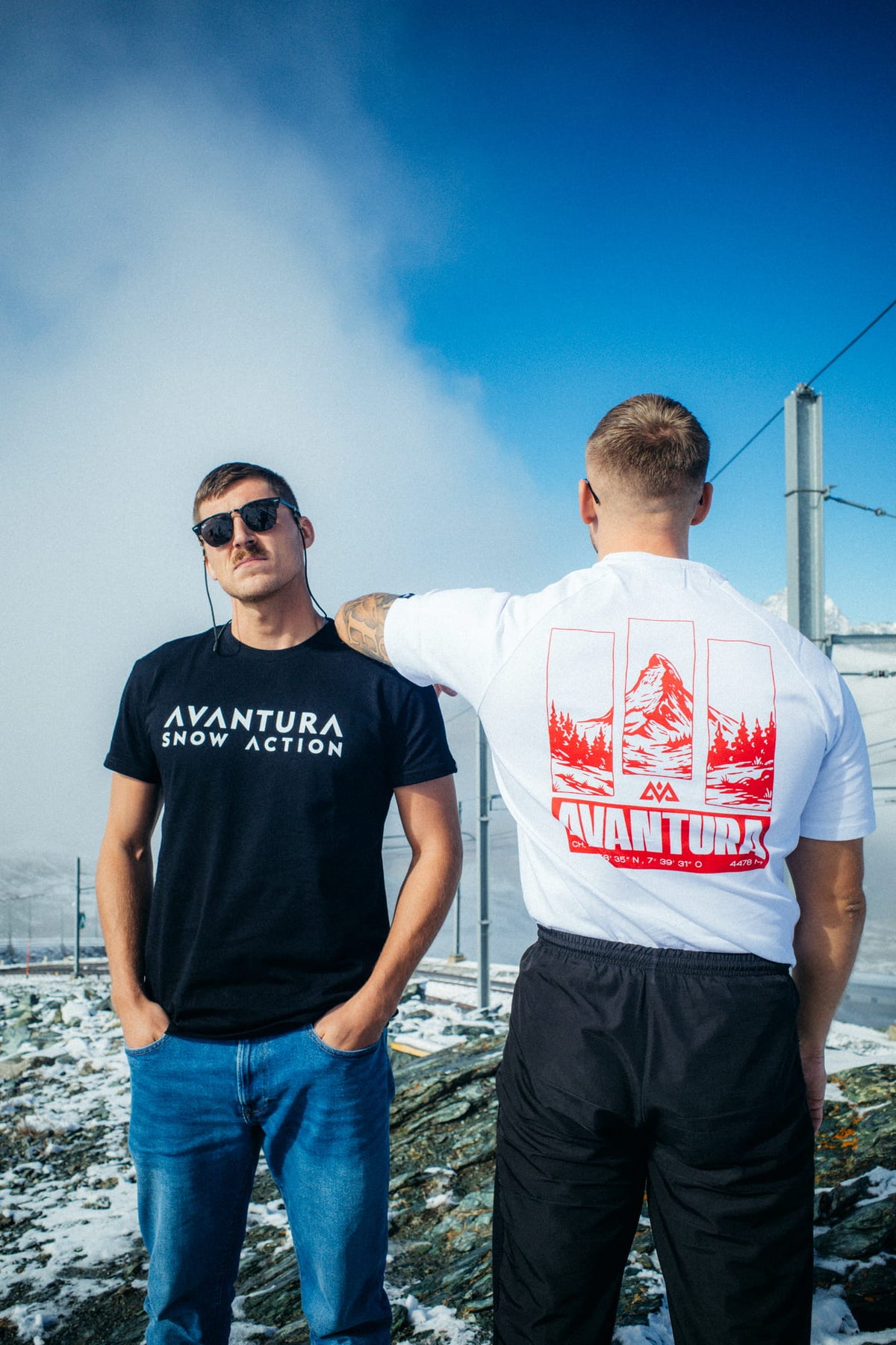Black T-shirt with white AVANTURA SNOW ACTION text in snow