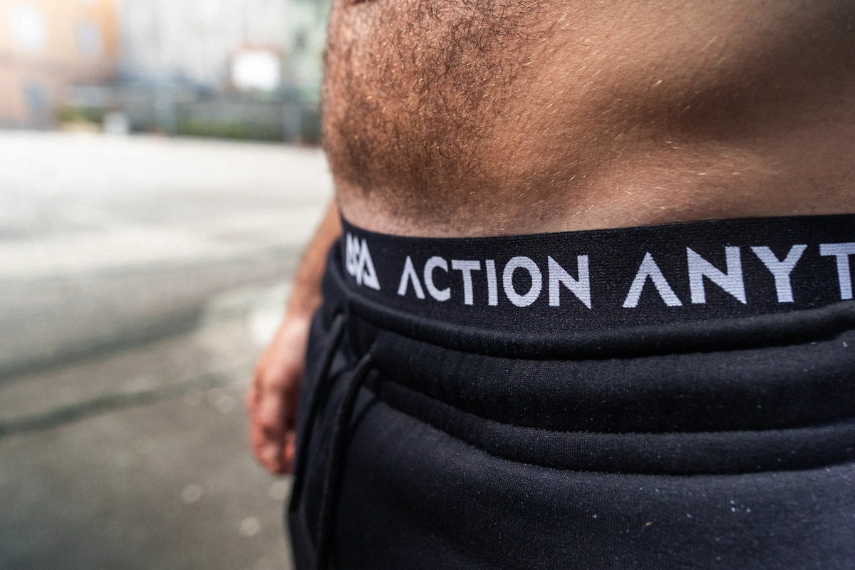 Black boxer shorts with white ACTION ANYTIME text on waistband