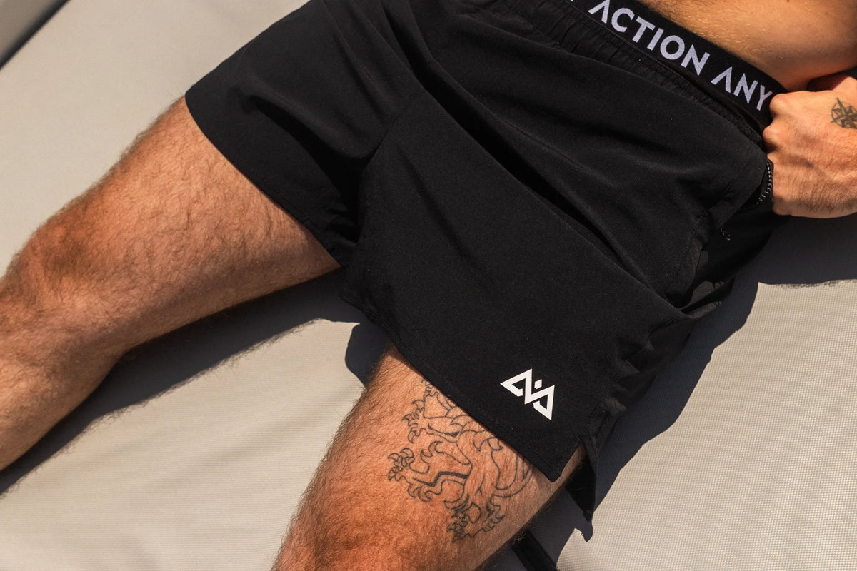 Black boxer shorts with white geometric logo at leg opening
