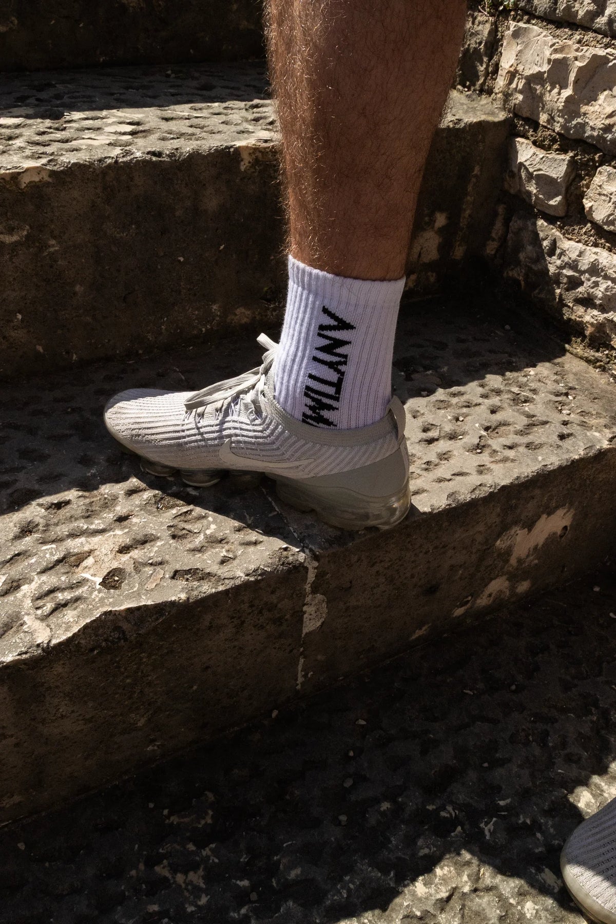 White ribbed crew sock with black 'ANYTIME' text detail
