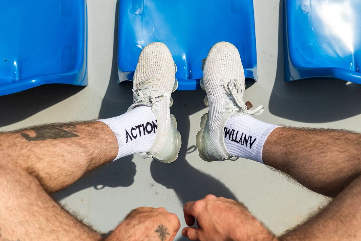 White ACTION ANYTIME socks worn with grey knit sneakers