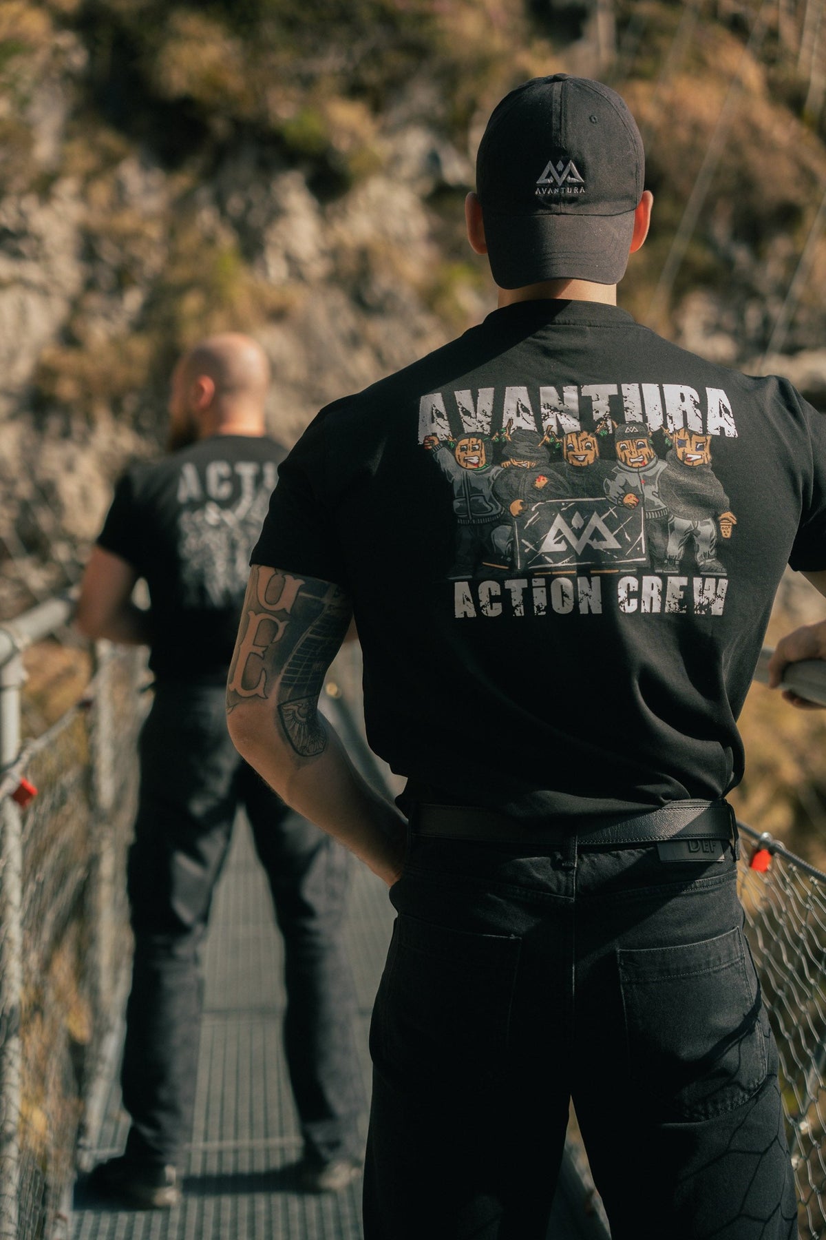 Close-up of distressed AVANTURA and masked figures back print on black T-shirt