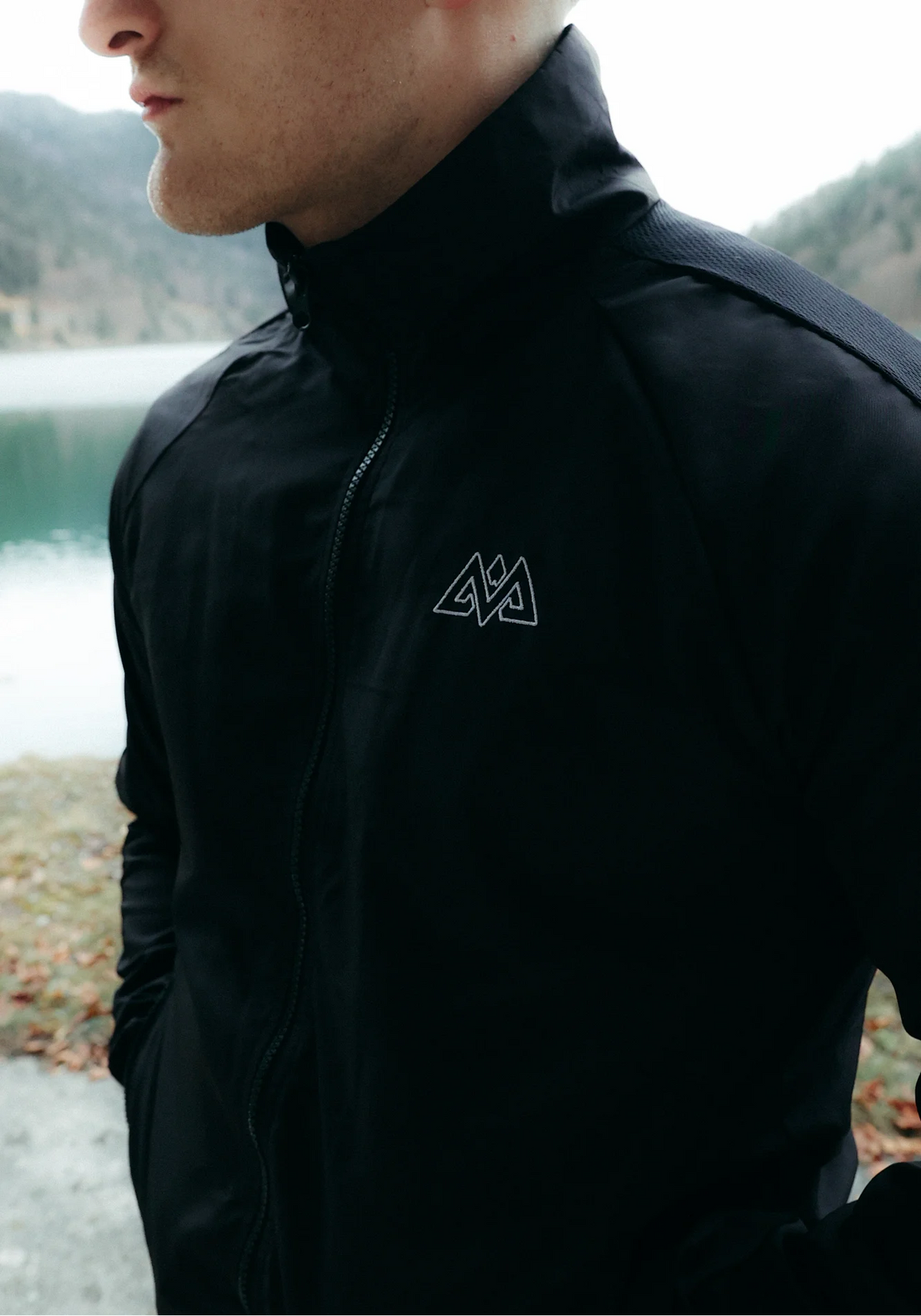 Close-up of black high-neck tracksuit jacket with shoulder texture detail
