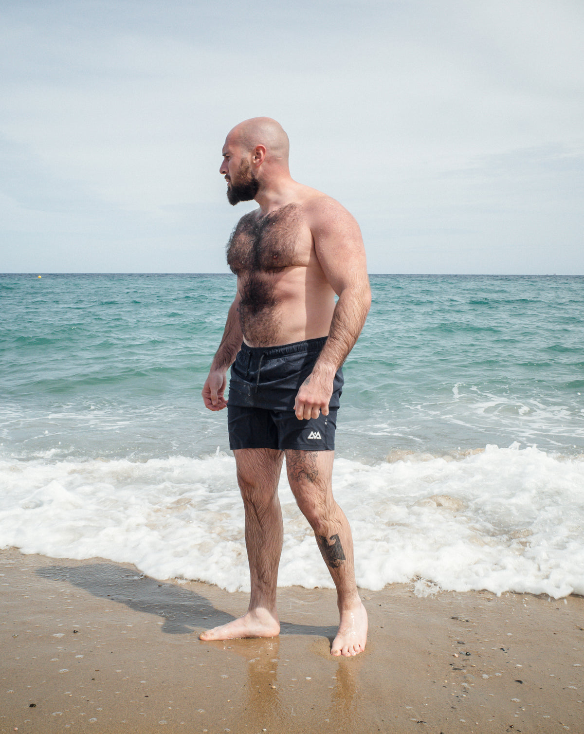 Side profile fit of navy swim trunks on model