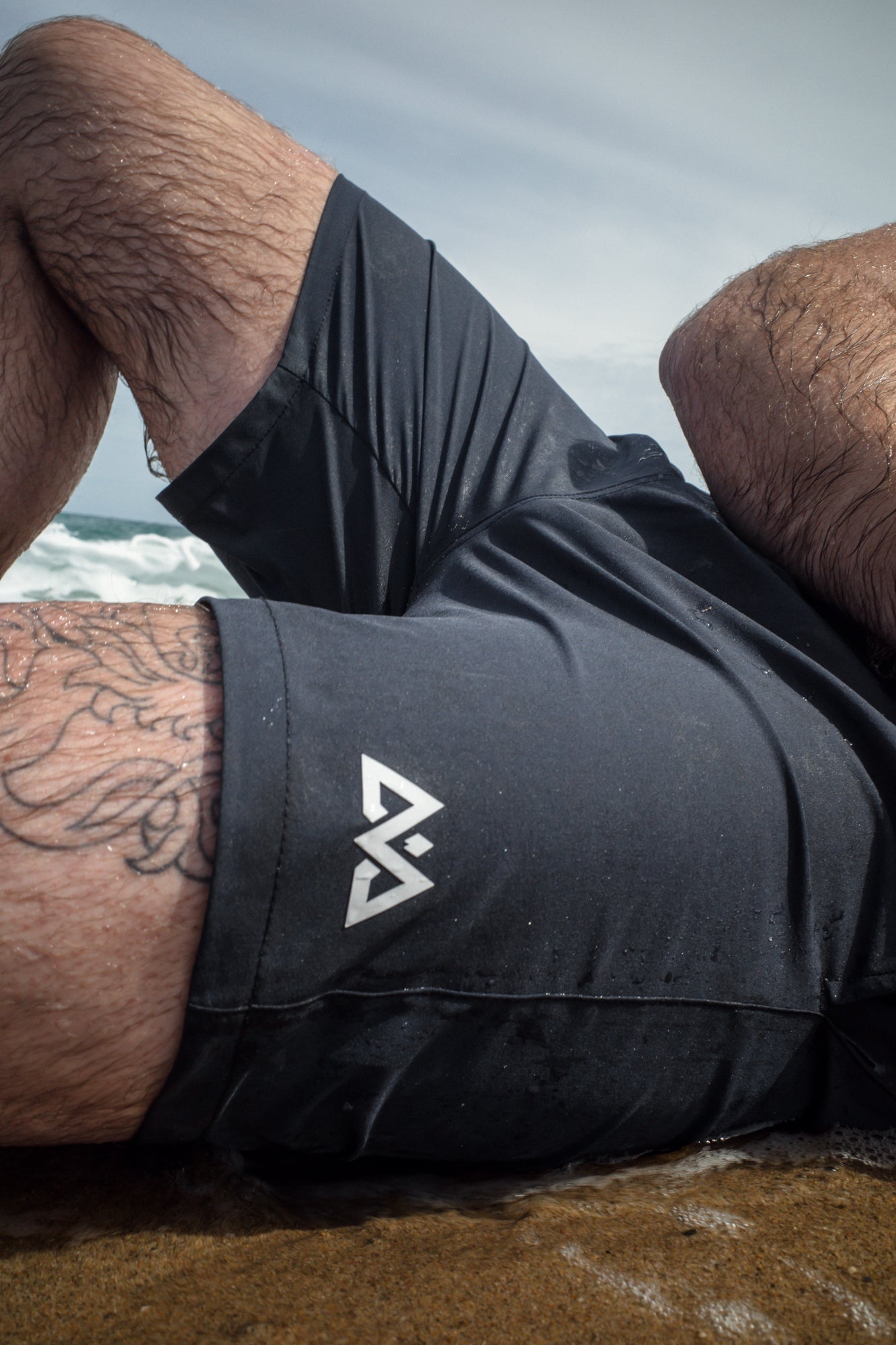 Black swim trunks with large white logo detail