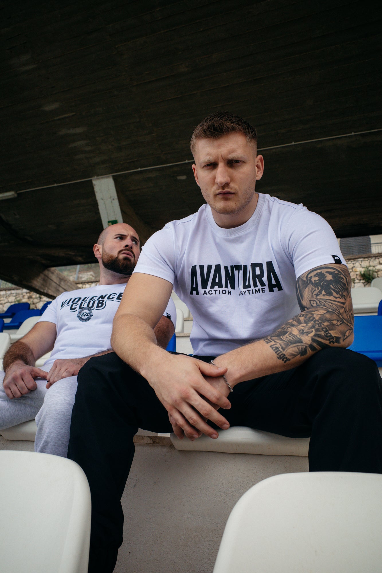 Close-up of white Avantura T-shirt sleeve label and chest logo