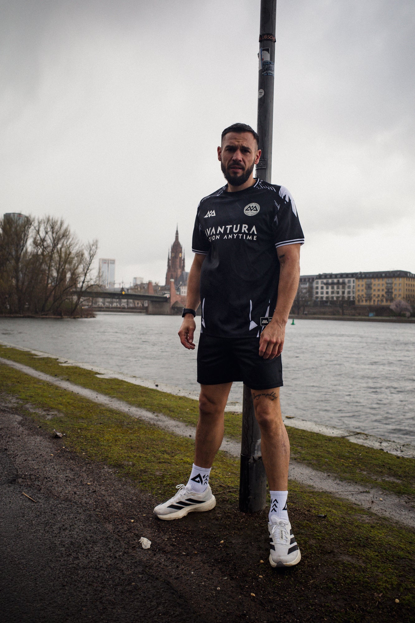 Black Avantura sports jersey with white shoulder graphics and chest logo