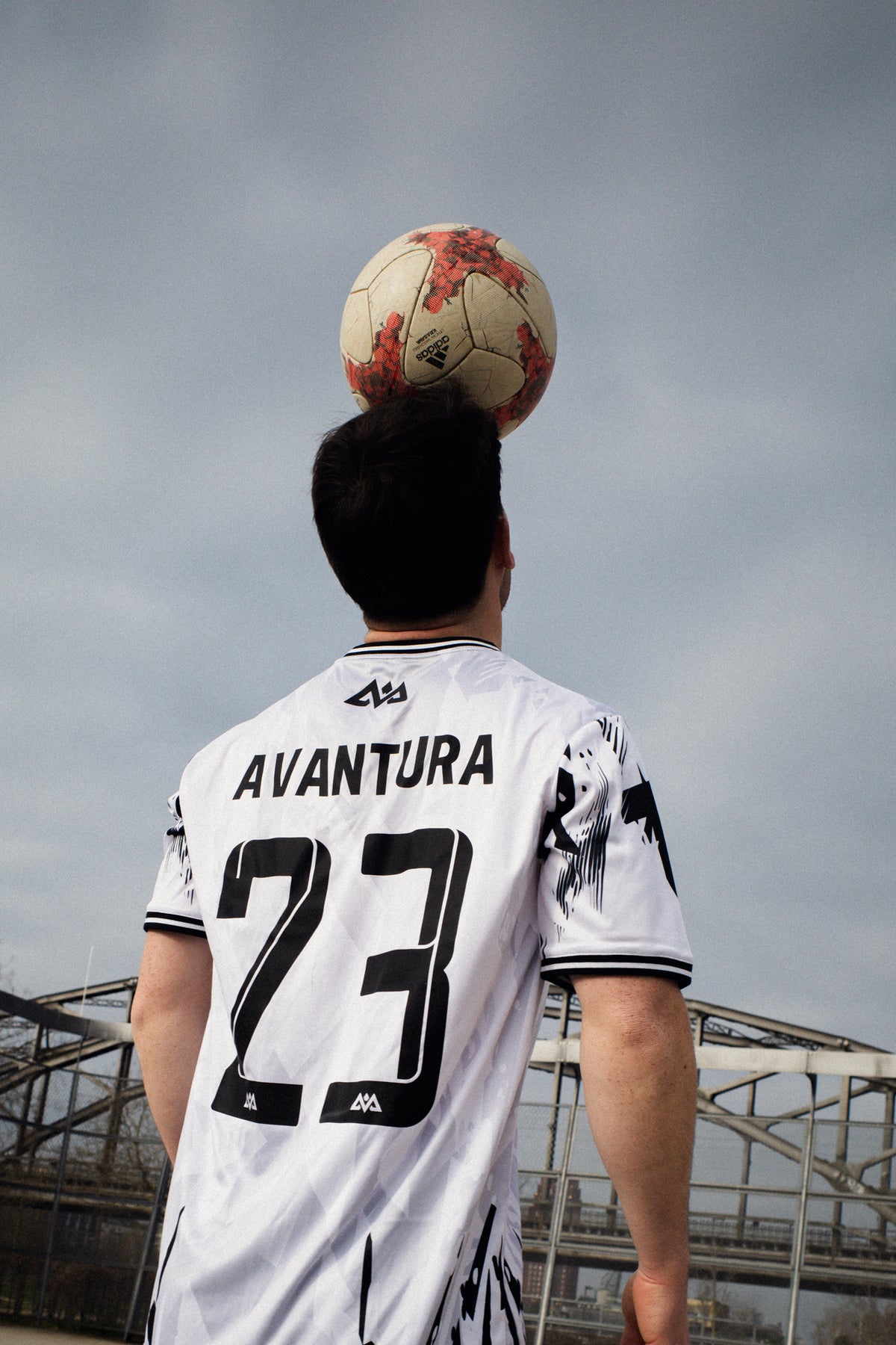 Back view of white Avantura jersey featuring large number 23 and brand name in black print