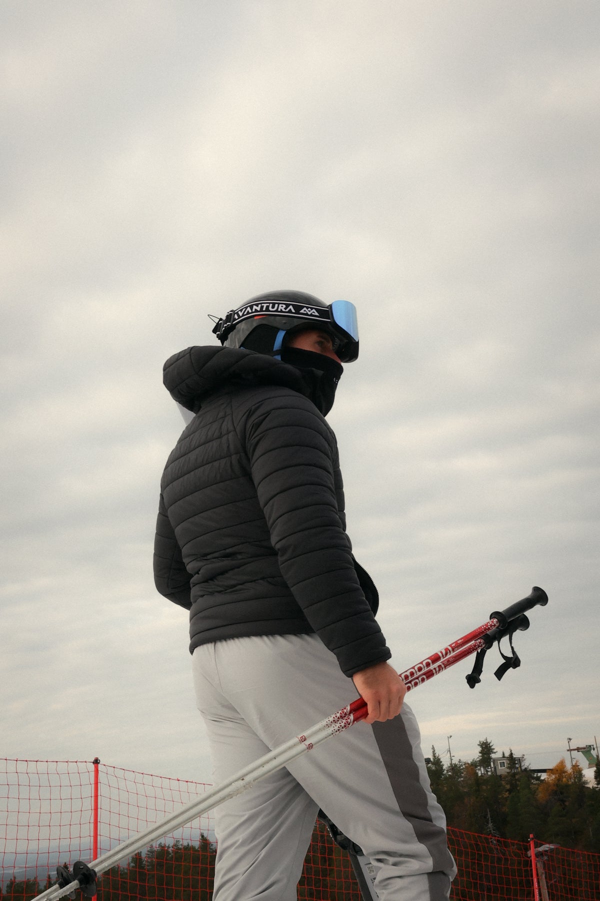 Skibrille mit blauer Linse auf schwarzem Helm im Skioutfit