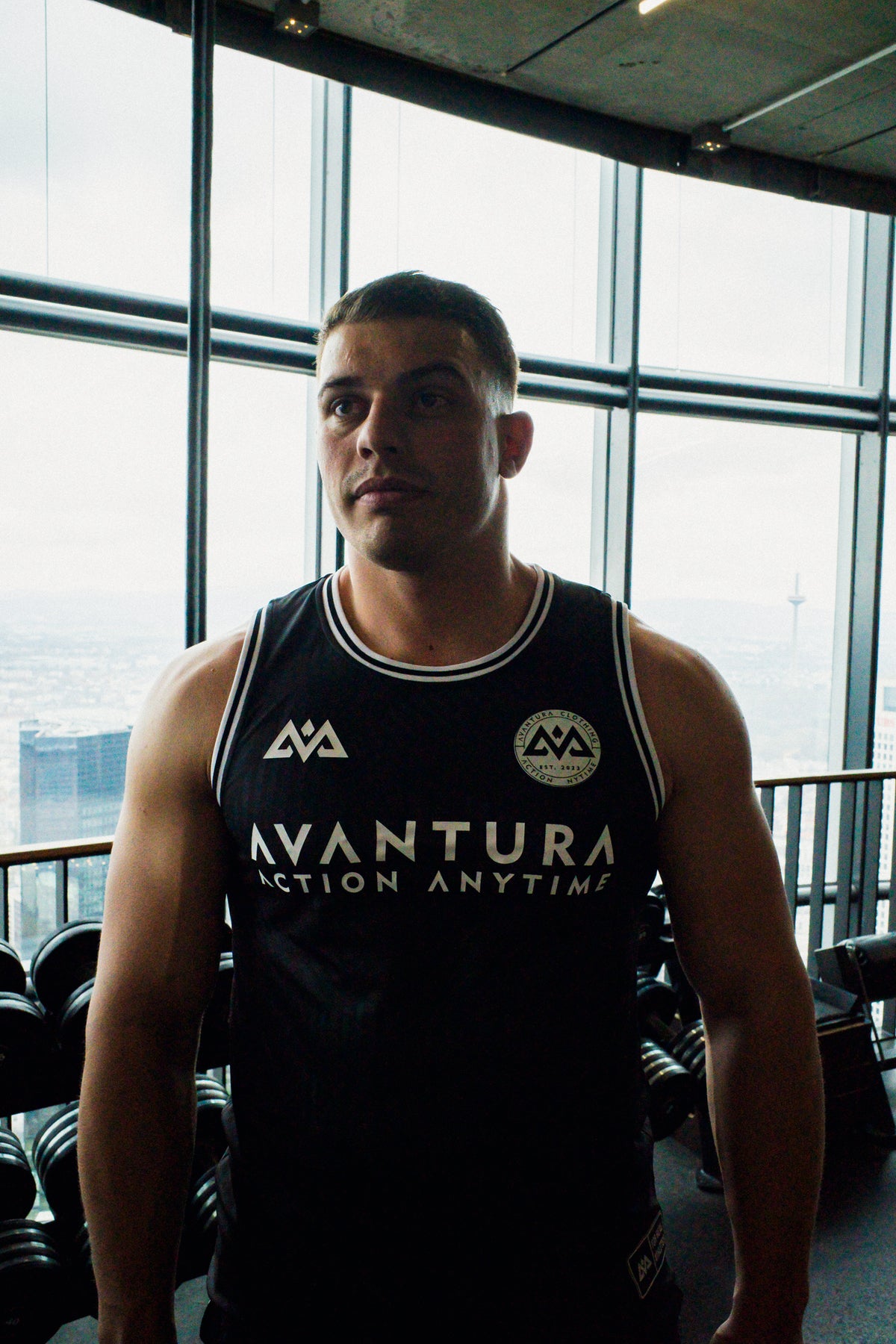 Front view of black Avantura jersey tank top with white chest slogan and trim
