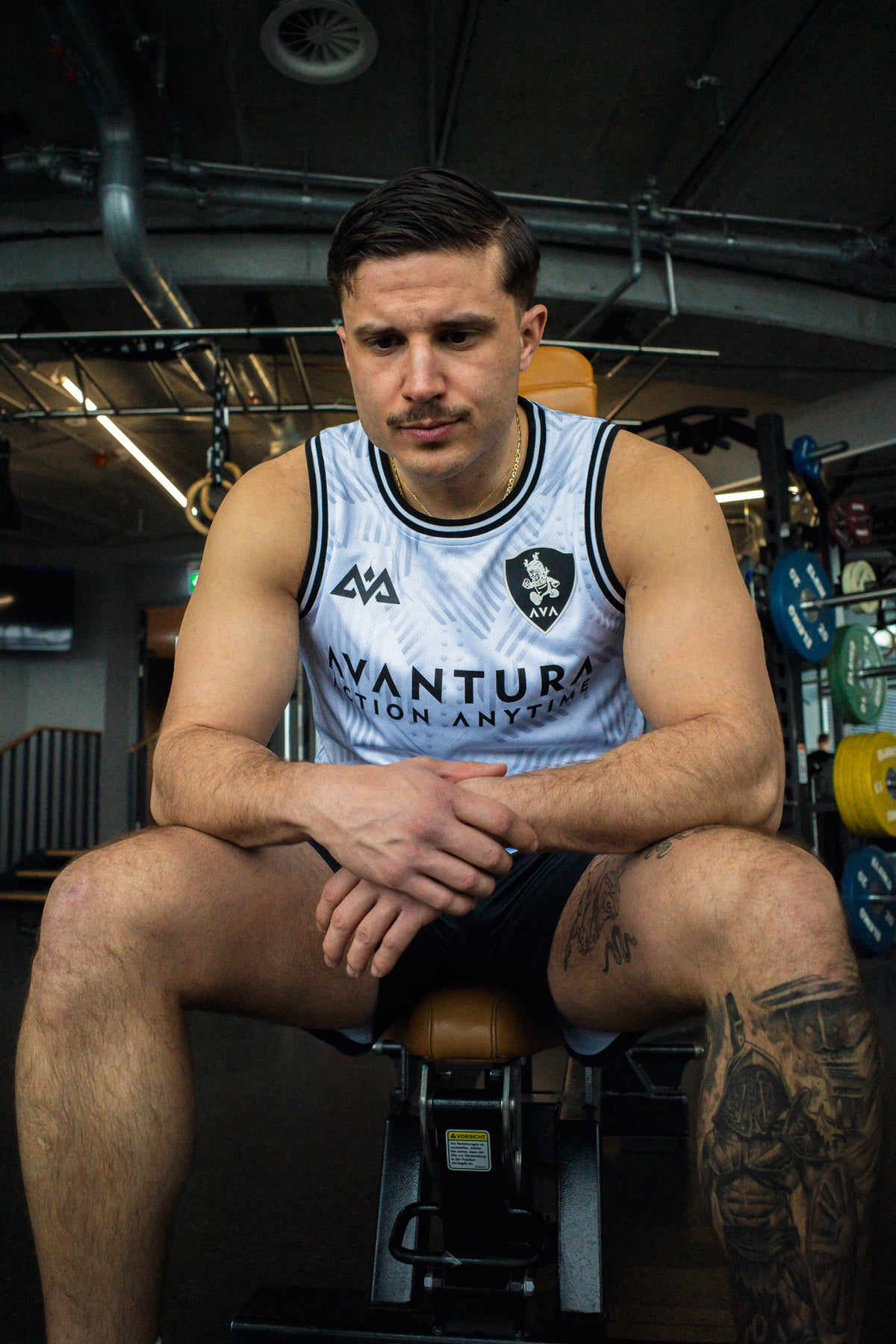 Front view of white Avantura sports tank top with shield and triangle logos