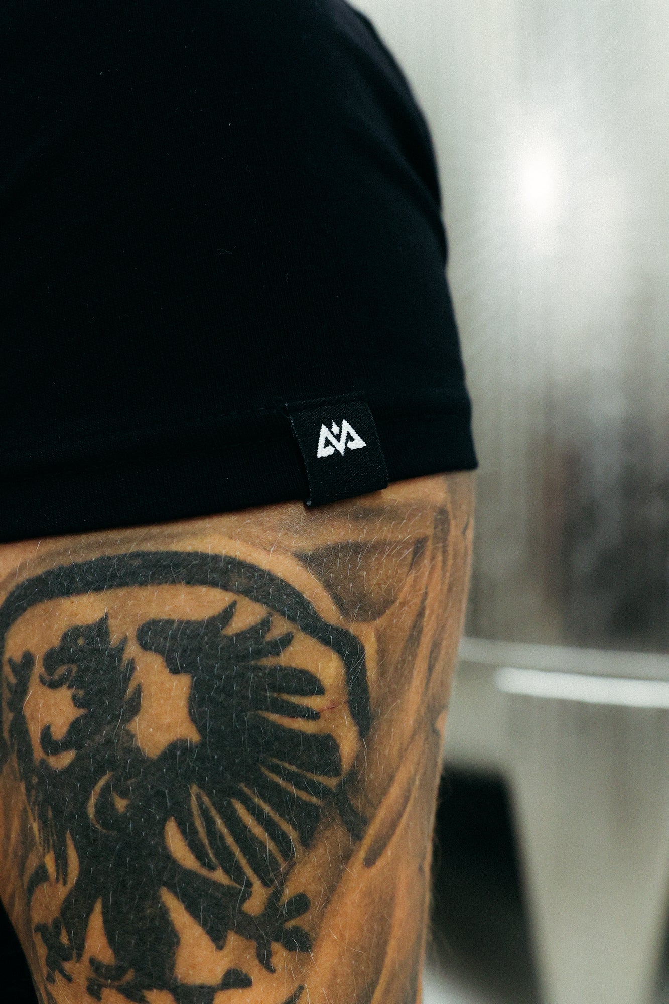 Avantura x Bembel black t-shirt sleeve woven label detail