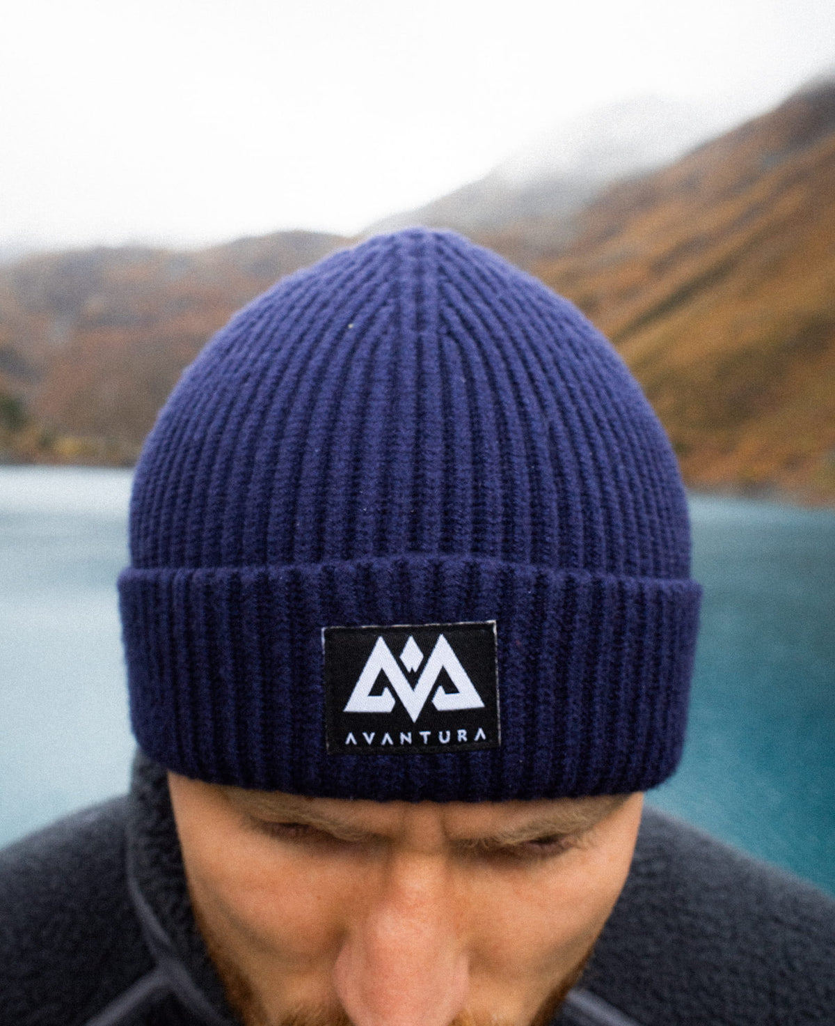 Nahaufnahme des gewebten AVANTURA Labels auf der Beanie