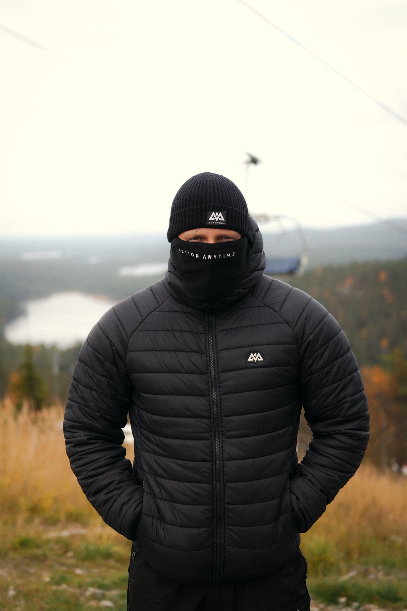 Black Avantura beanie with white mountain patch logo worn outdoors