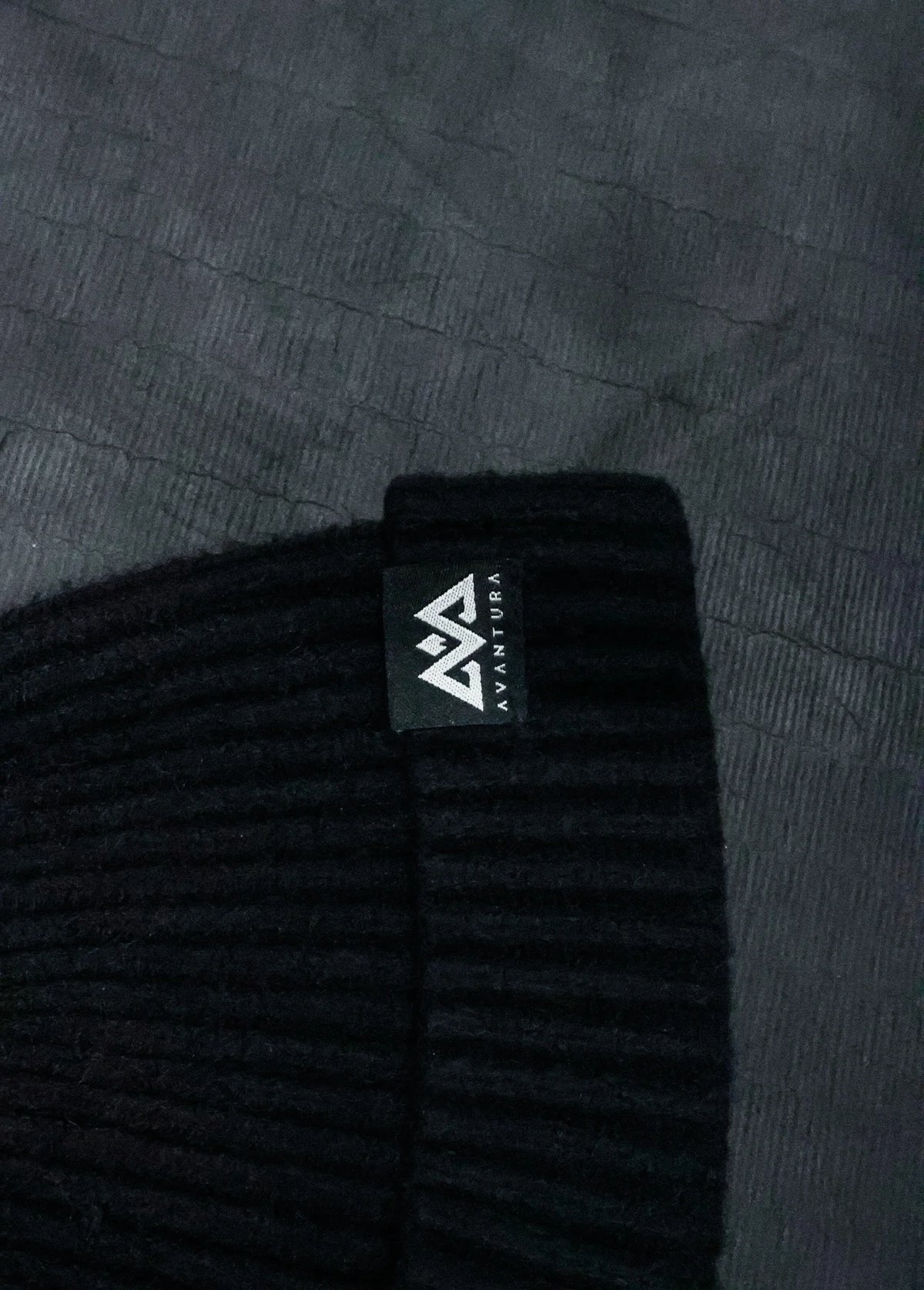 Schwarze Strickmütze mit kleinem gewebtem Logo und gerippter Textur