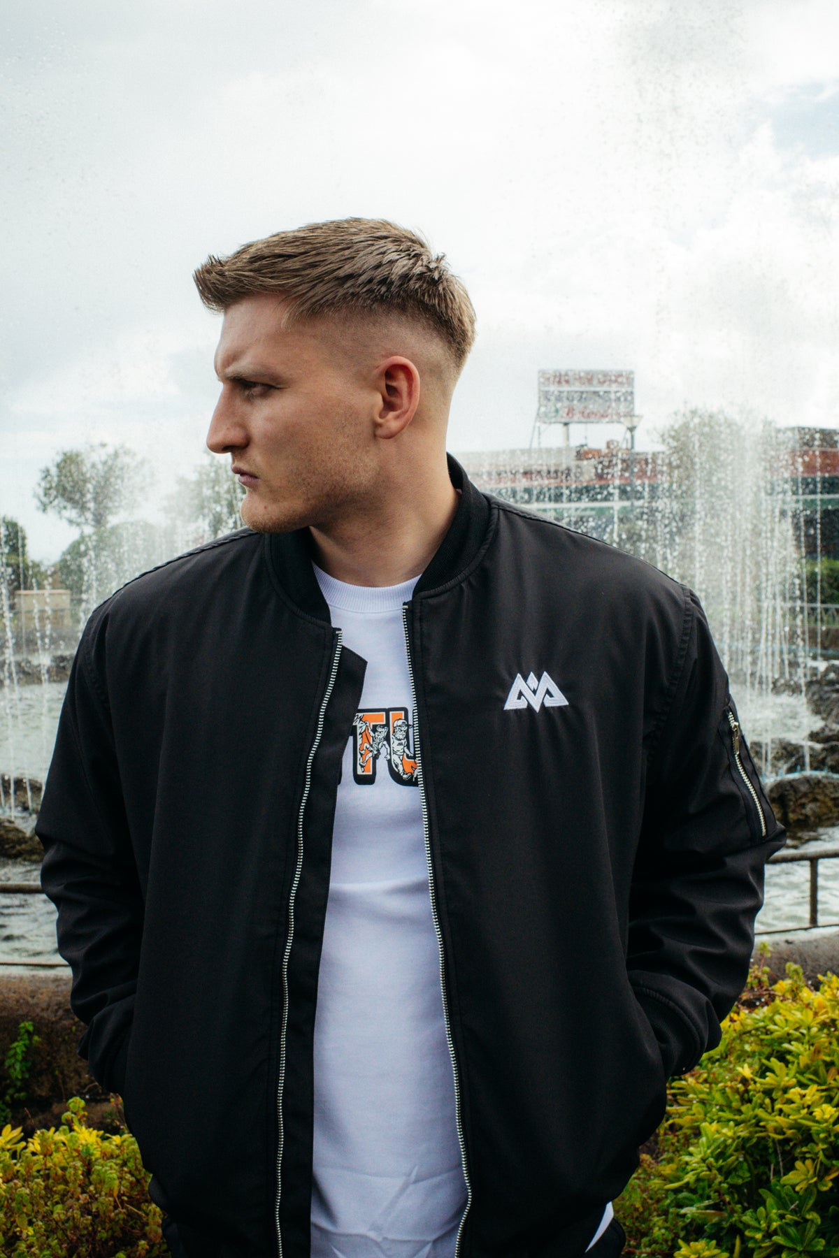 Man wearing zipped black bomber jacket with ribbed cuffs