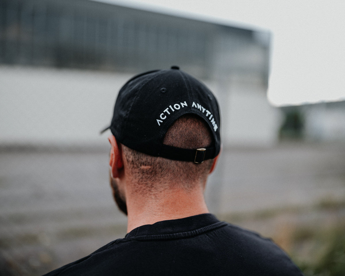 Rear fit of black cap with adjustable buckle and back text